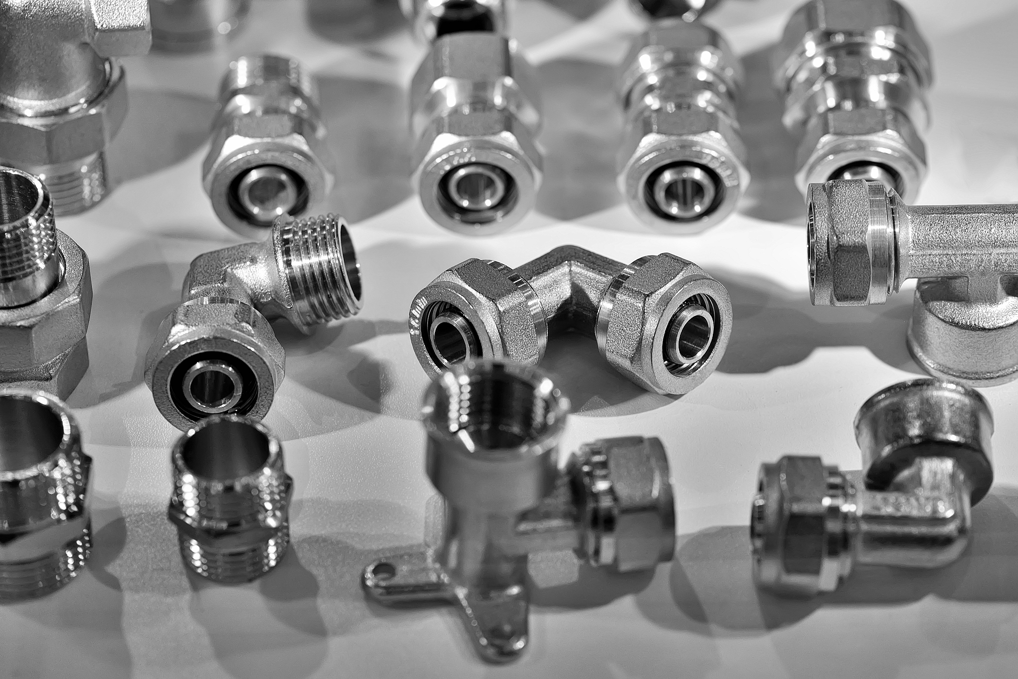 a variety of plumbing pipe connectors. black and white toned