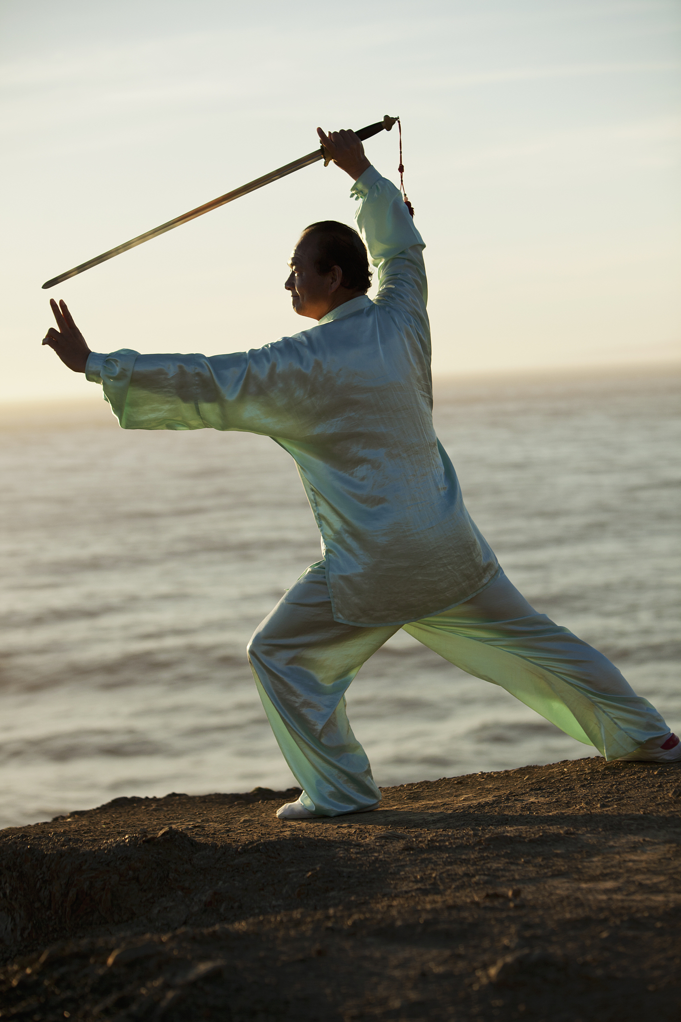 man practicing tai chi with a sword.