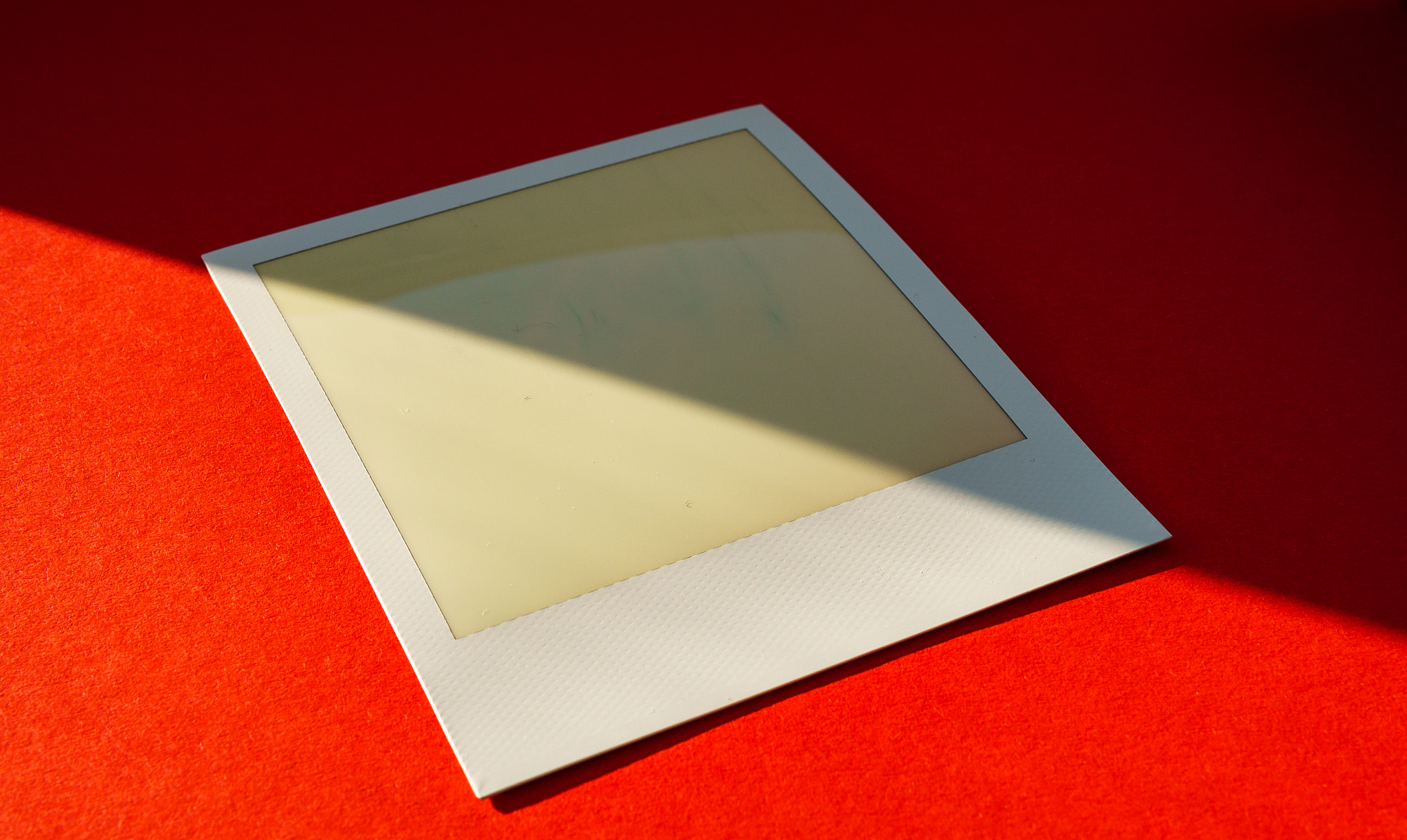 old and empty instant film or photo frame on red background with