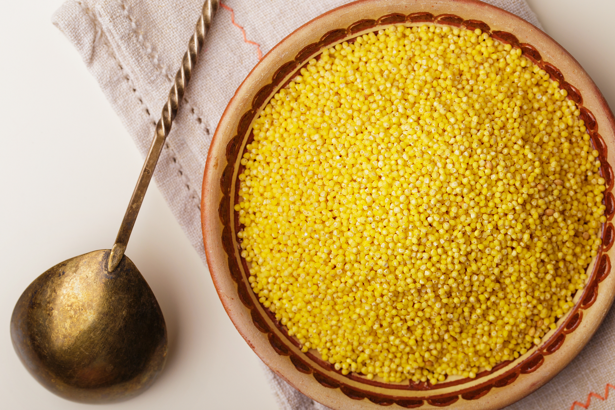millet or foxtail grains on plate, spoon