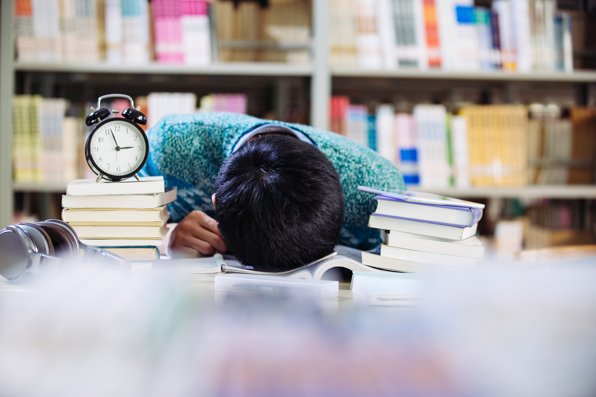 young asian man naps in library