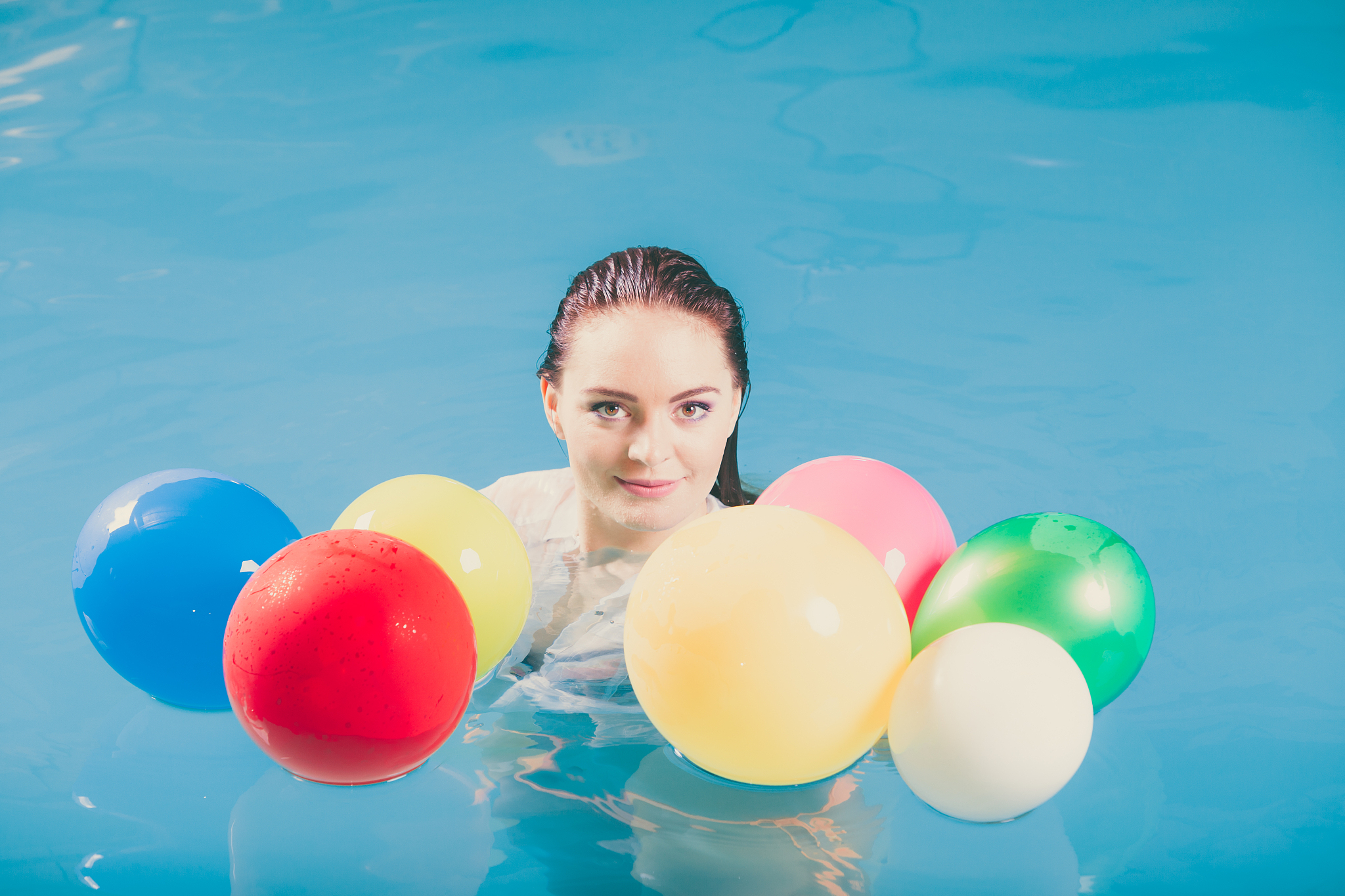 happy woman in water having fun with balloons