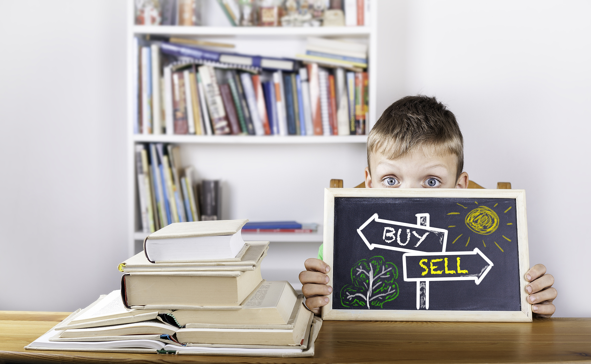 buy, sell signpost drawn on a blackboard