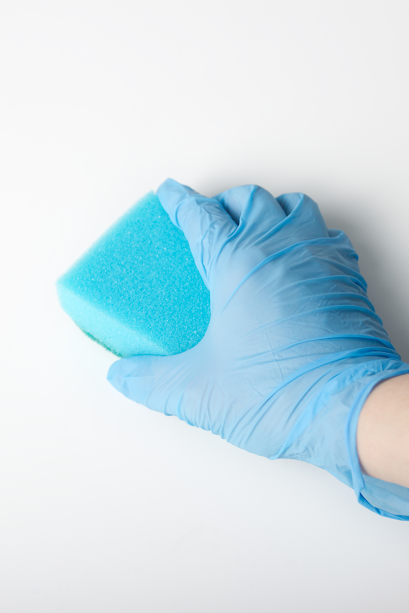 female hand in the commercial glove wash white table blue cloth