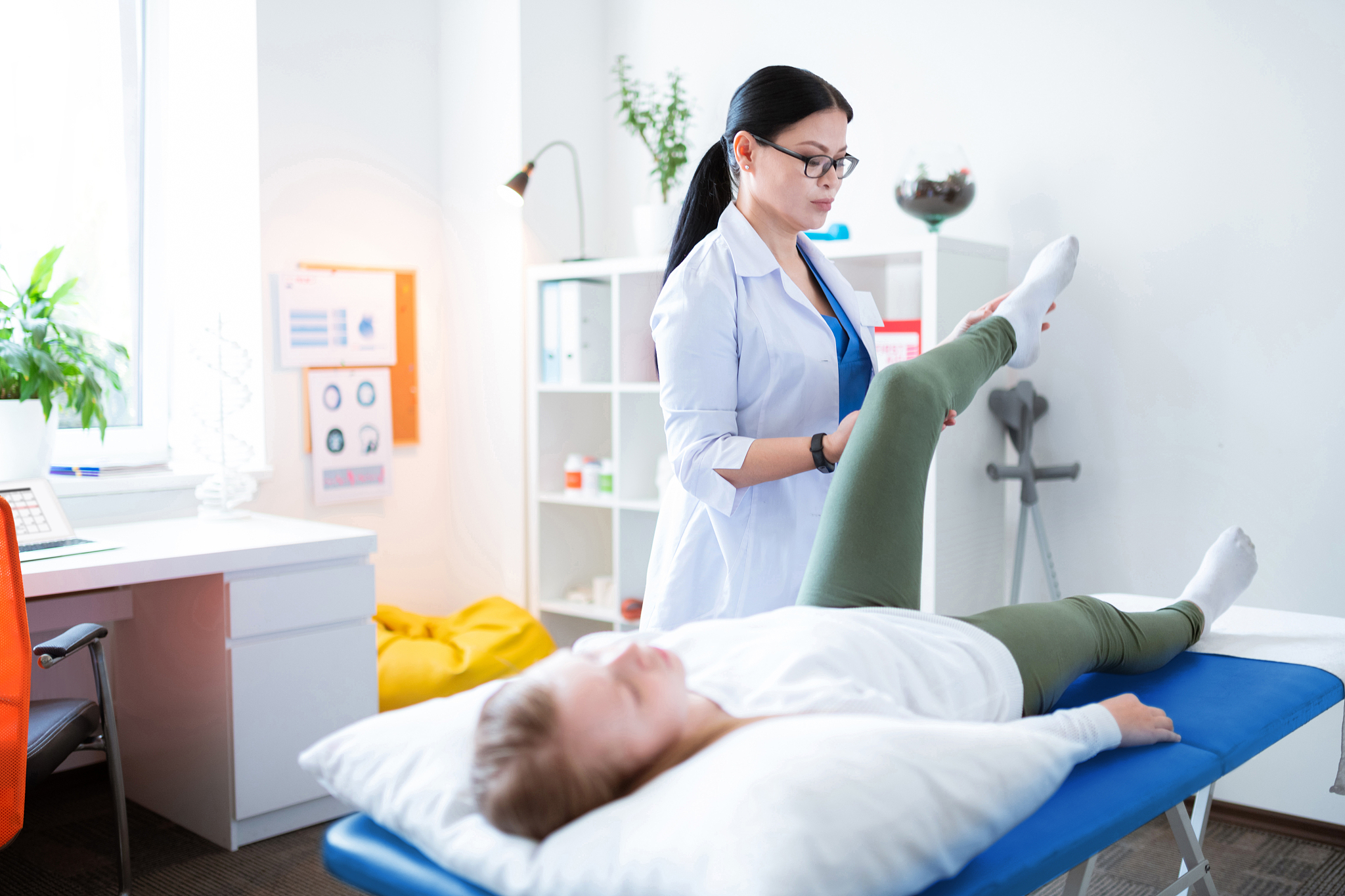 focused long-haired physical therapist being involved in examina