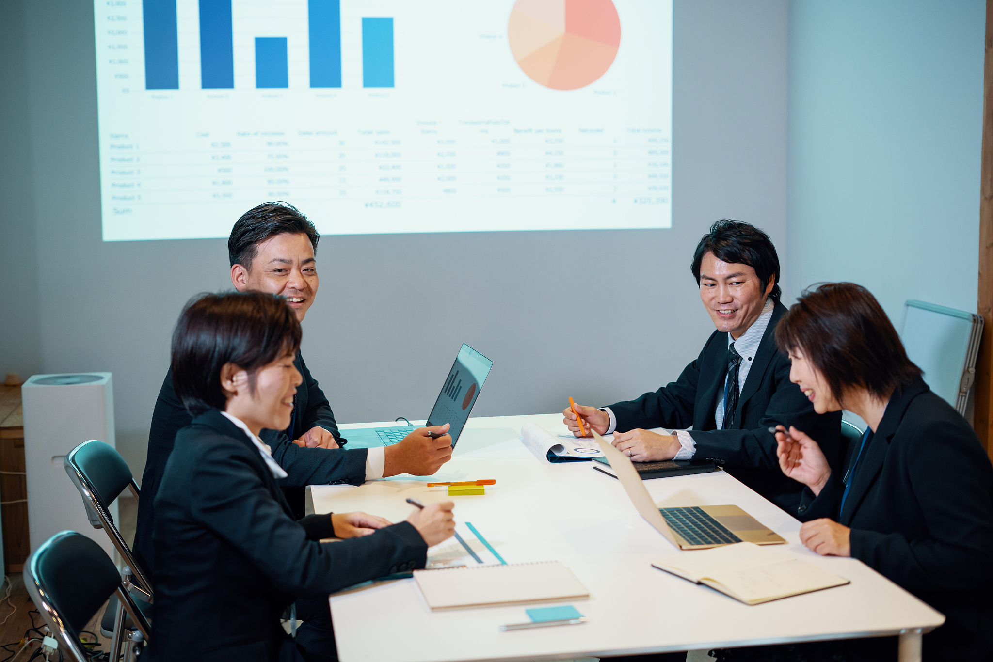 business people having a meeting in a corporate office while usi