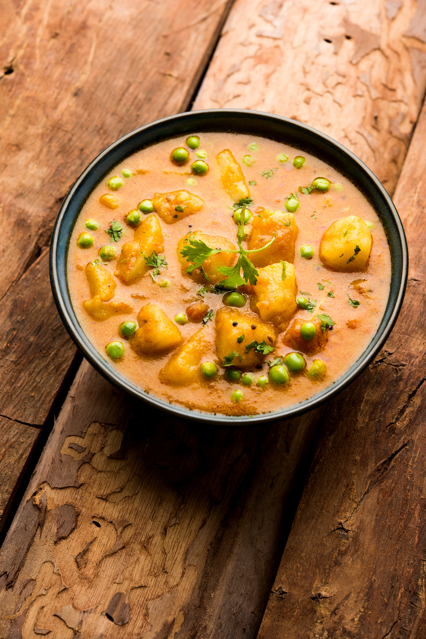 indian aloo mutter curry - potato and peas immersed in an onion 
