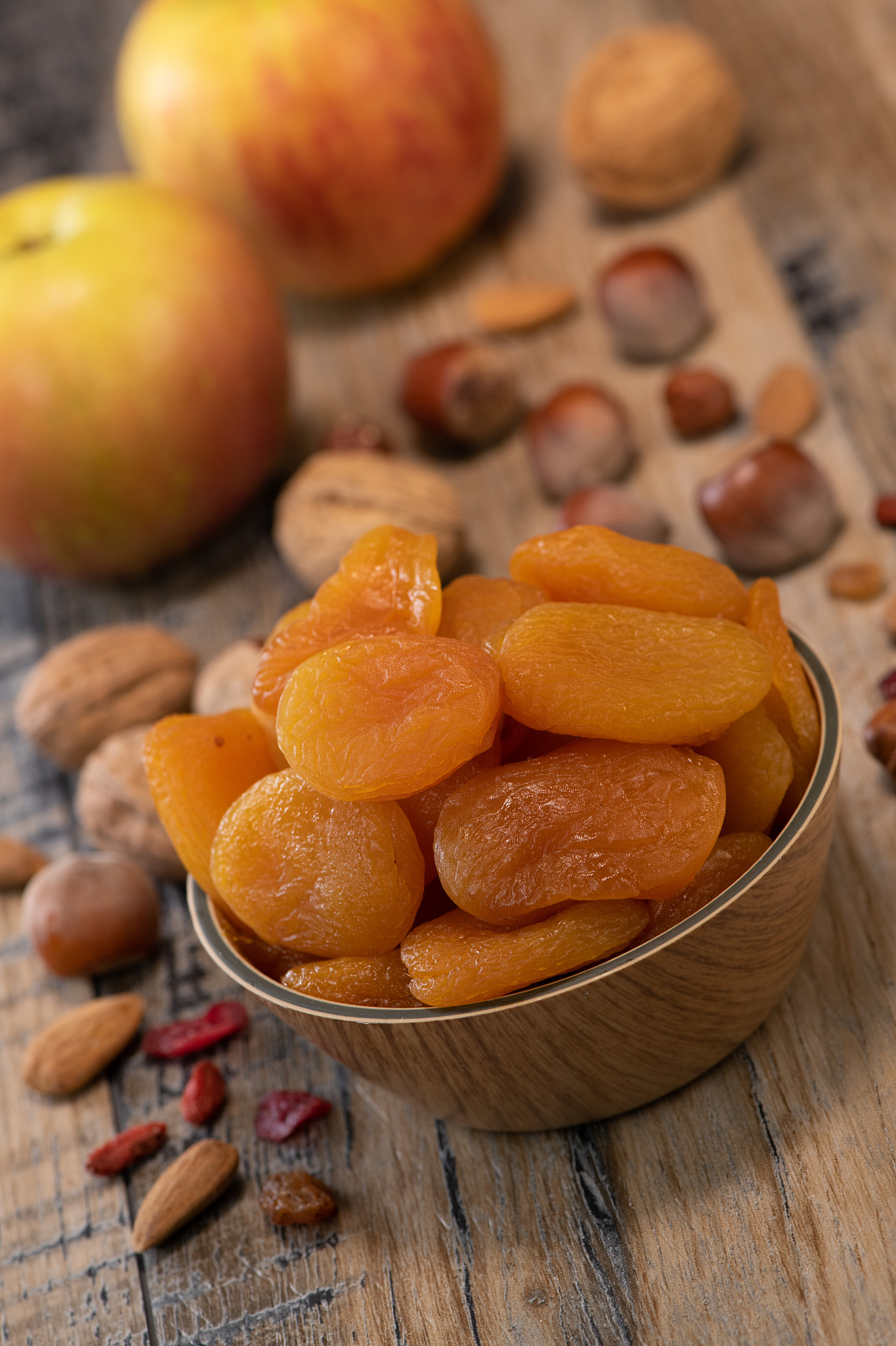 apricots, dried fruit and apple composition on wood background
