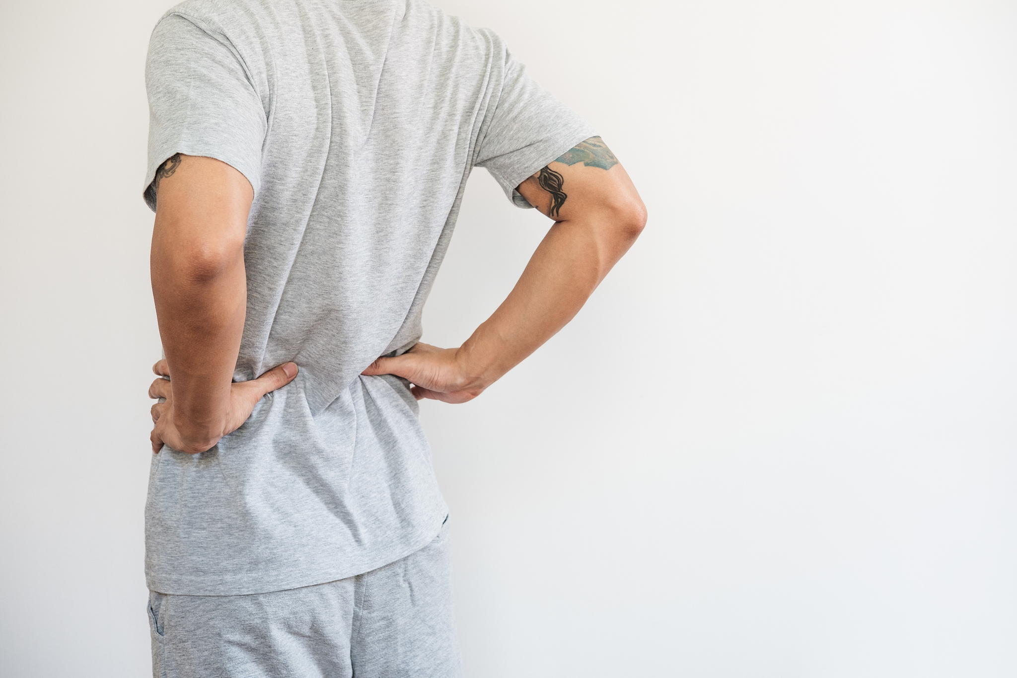 a man touching his back. back pain, backache and waist pain, on 