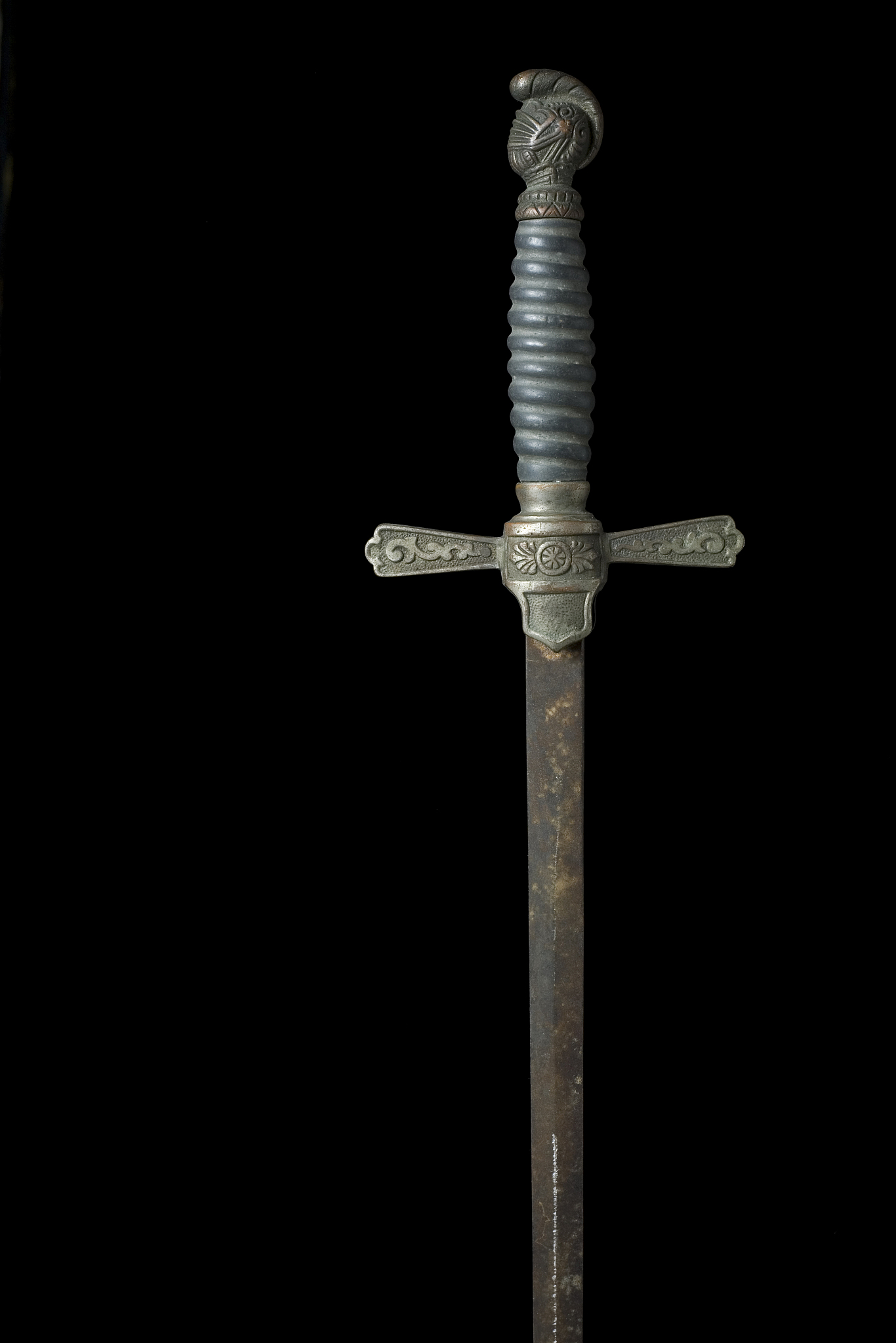 antique sword on black with ornate handle and rusty blade.