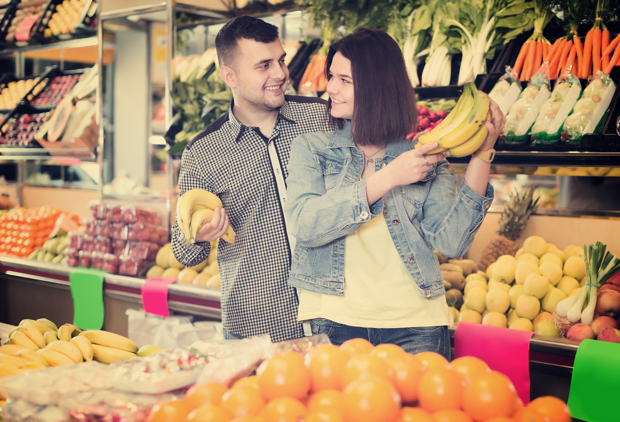 smiling couple examining various fruits