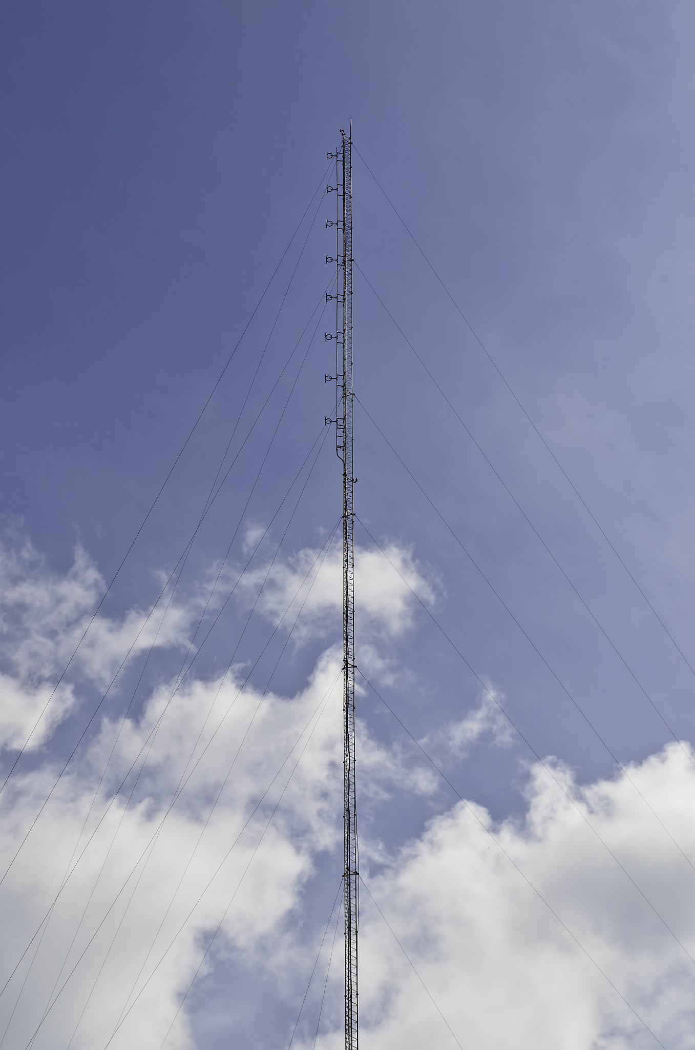 telecom tower for radio mobile against blue and cloudy sky