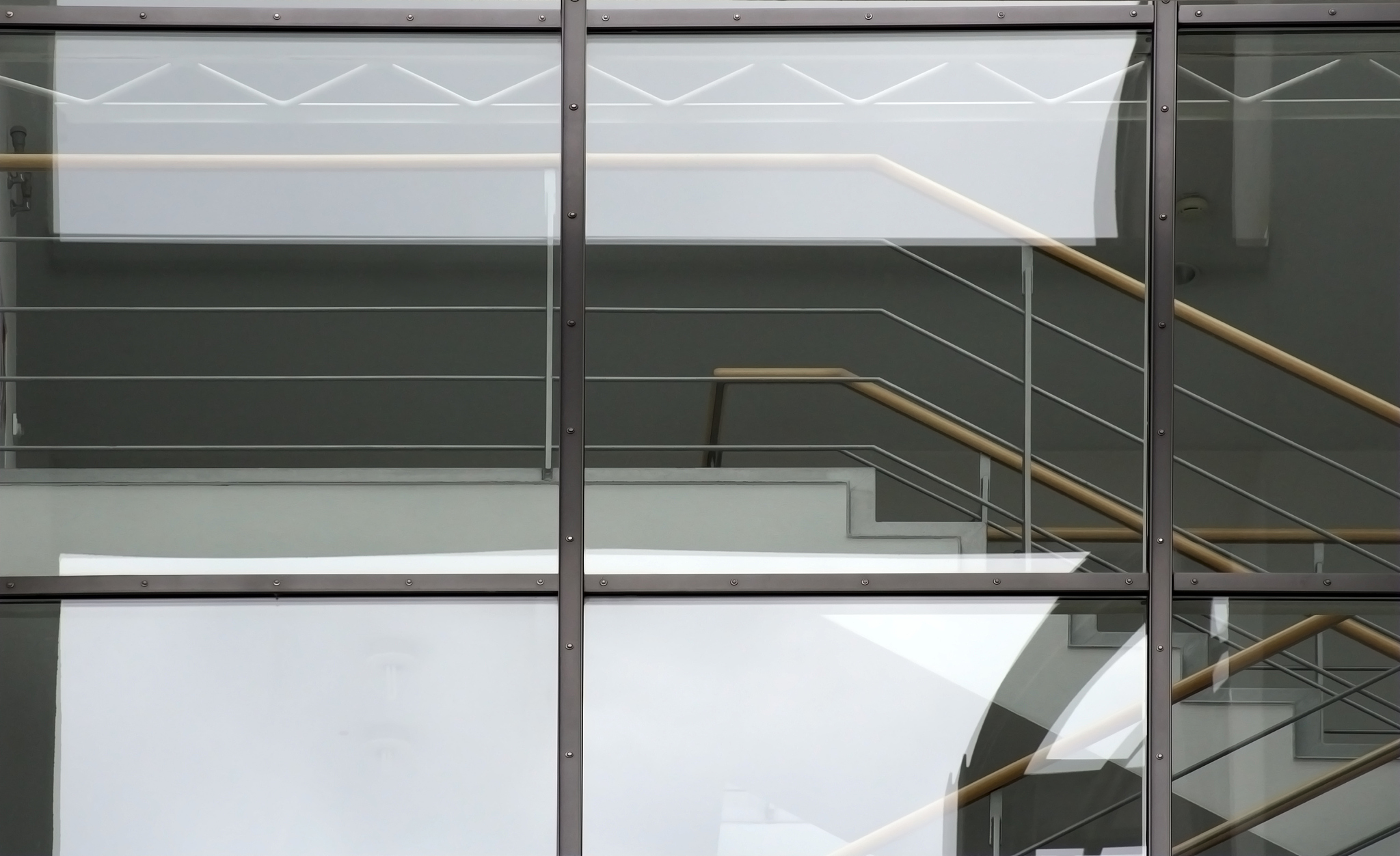 part of staircase. two flights of stairs seen through glass.