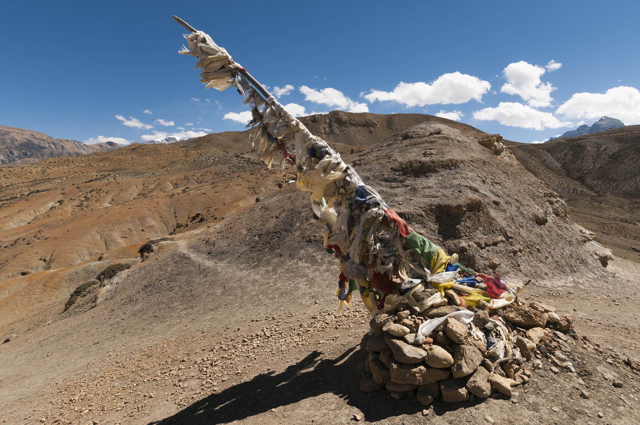 cairn and prayer flags at mountain pass