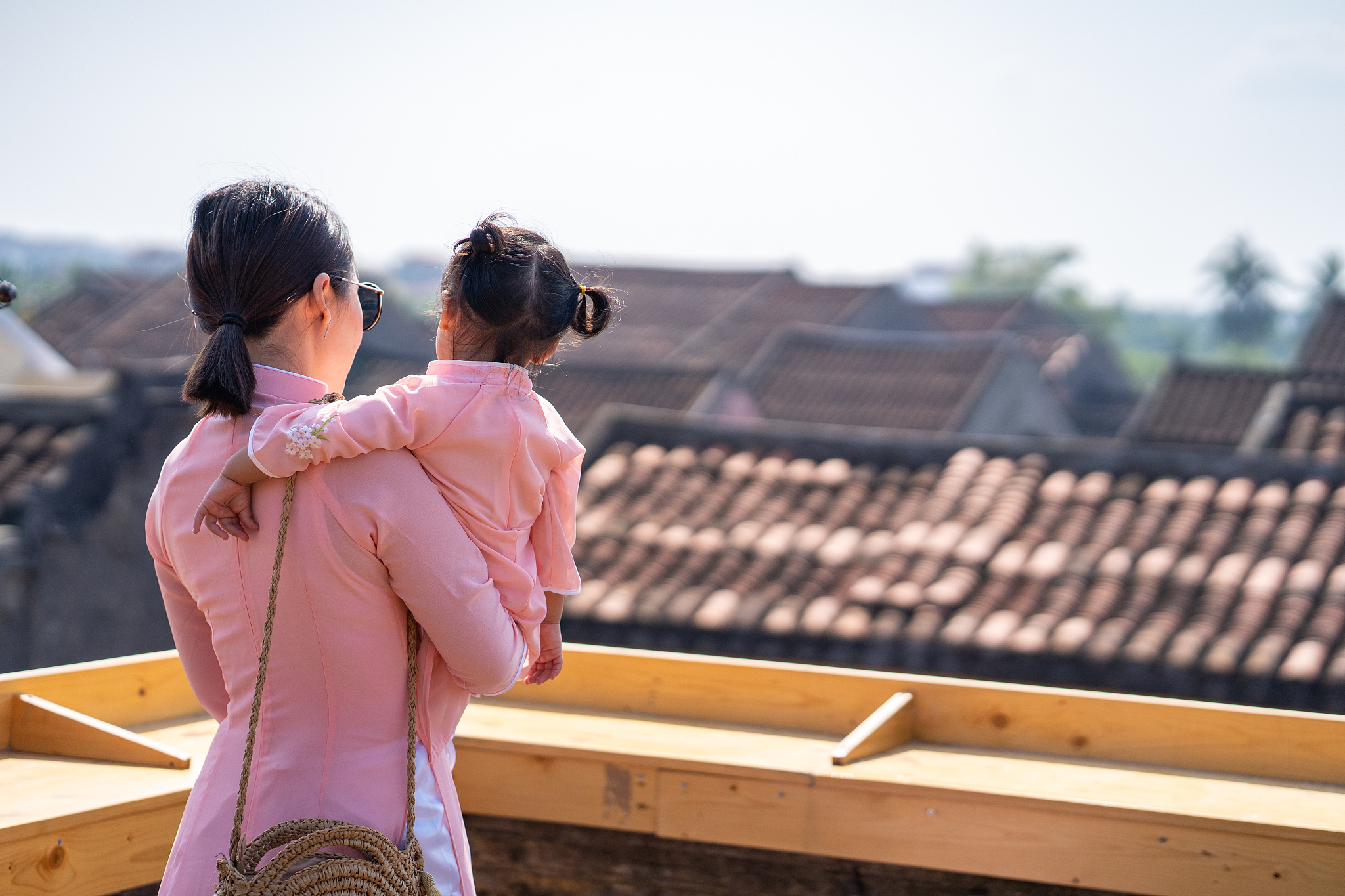 rear view of woman holding daughter on terrace