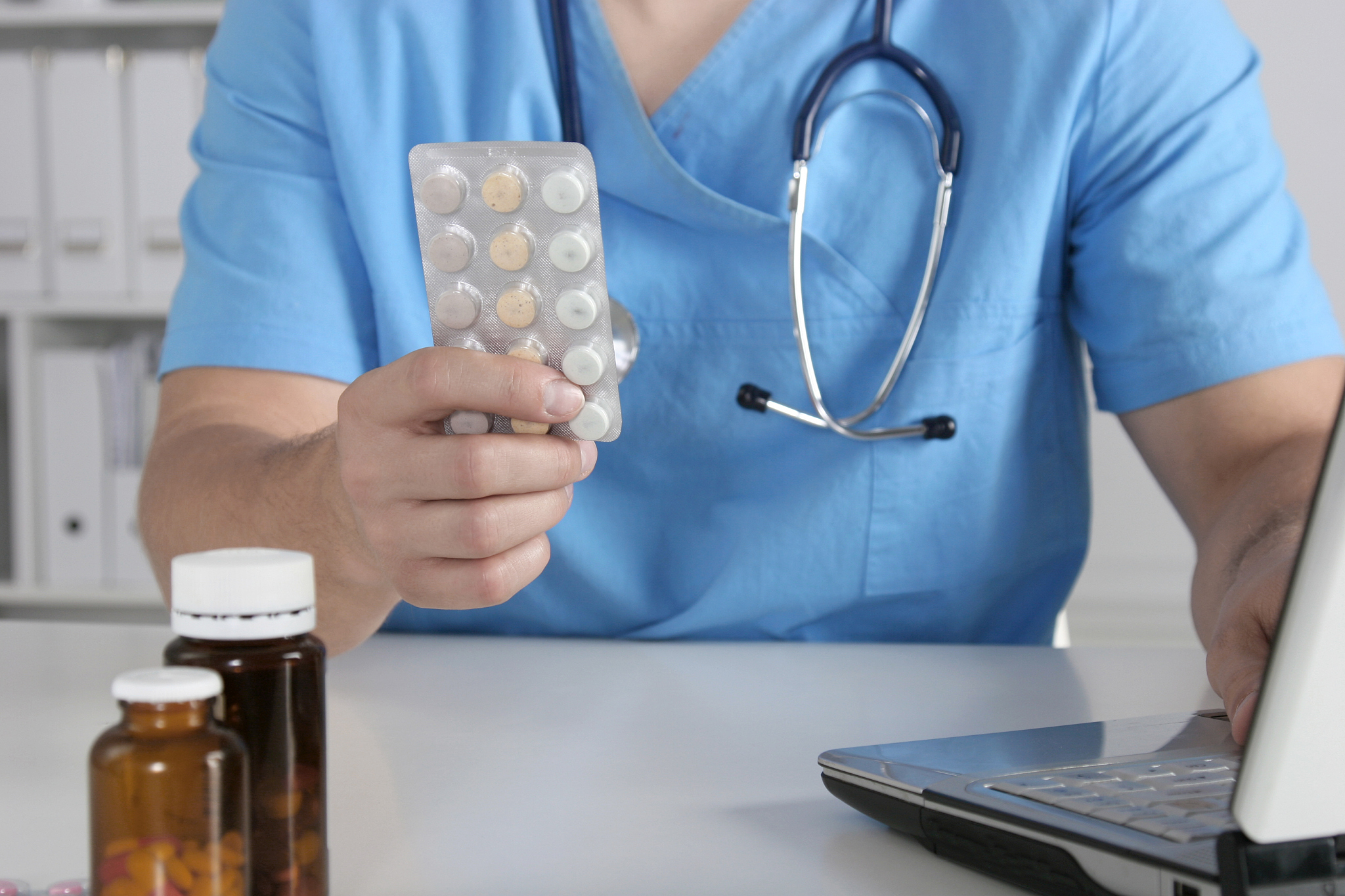 male doctor sitting at the table and holding bottle