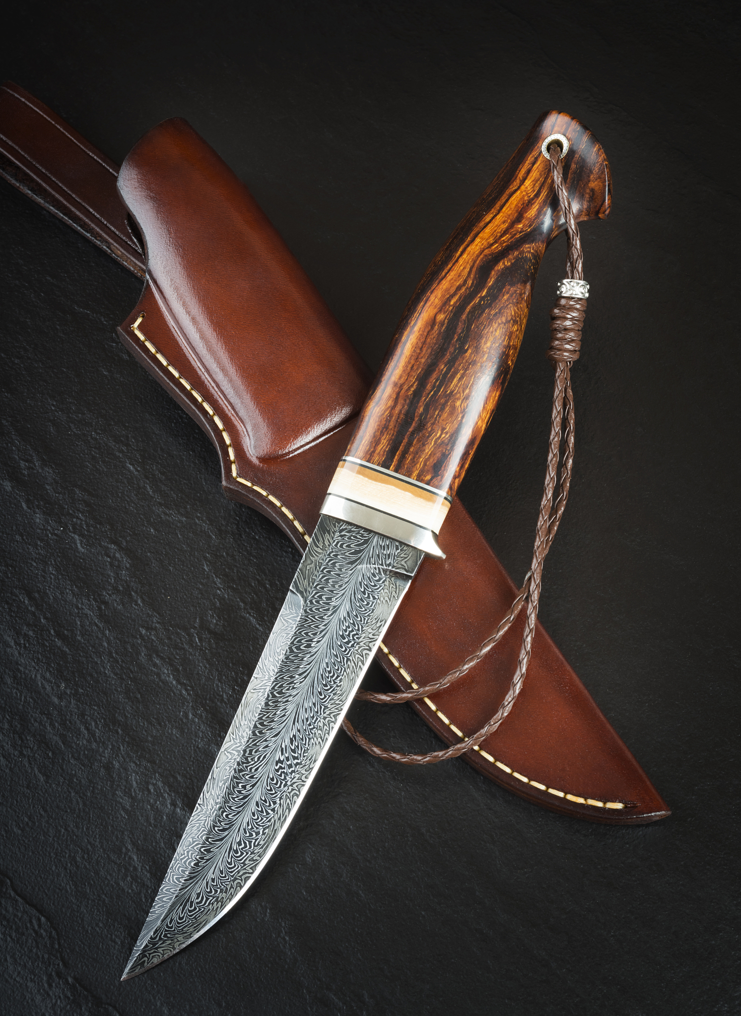 hunting knife from damascus mosaic with mammoth tusk on a black 