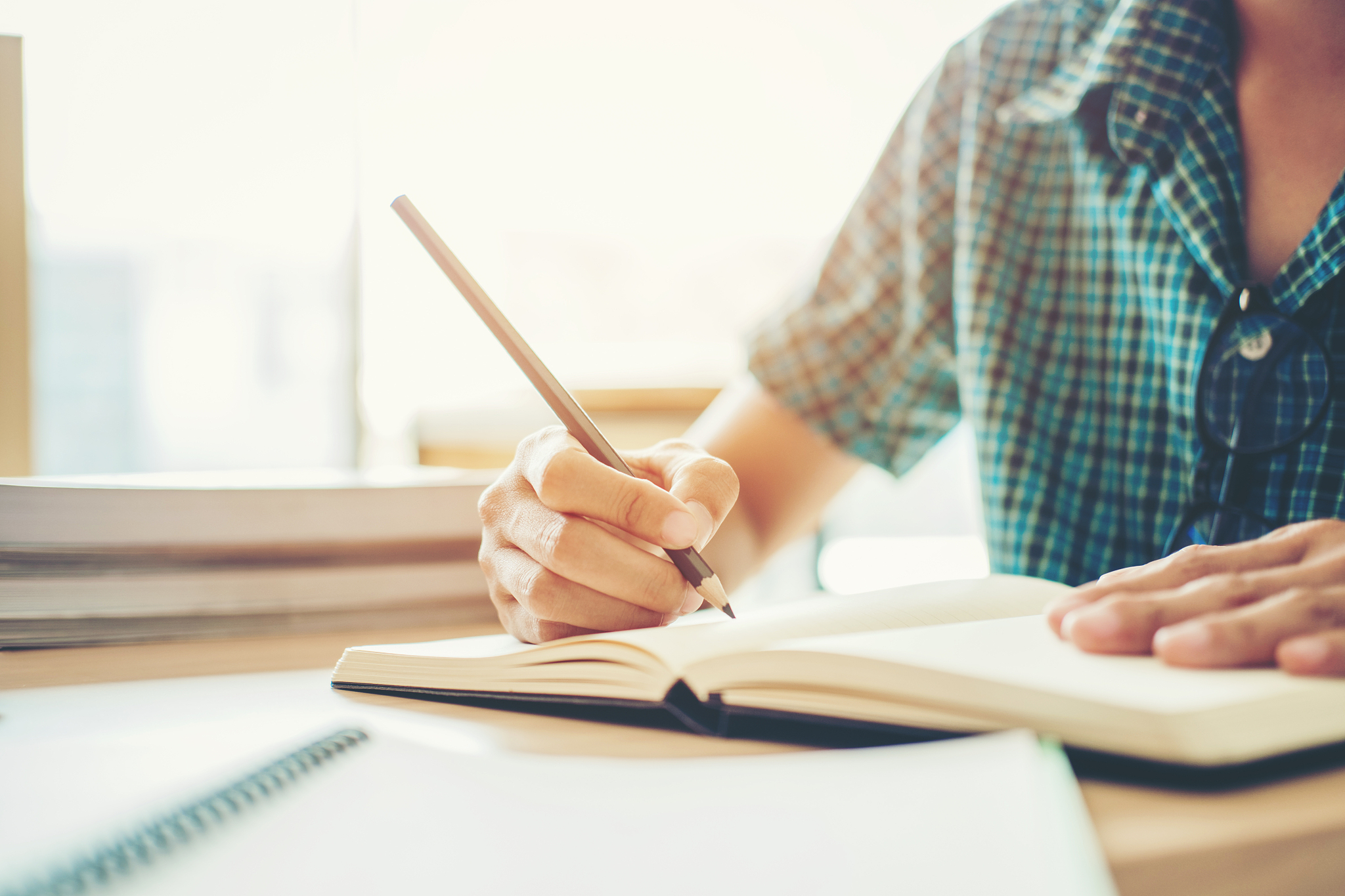 high school or college student studying and reading in library