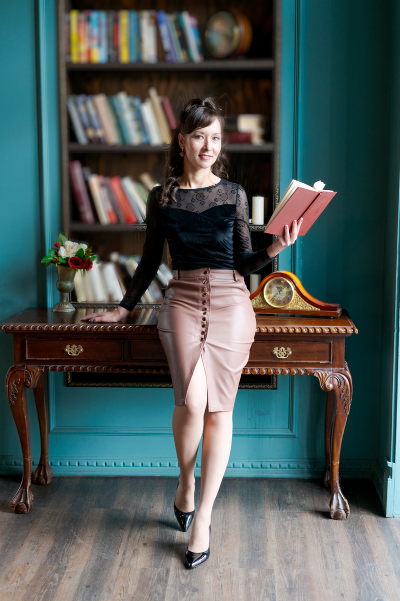 <strong>优雅</strong>的女士站在古典图书馆手持一本书