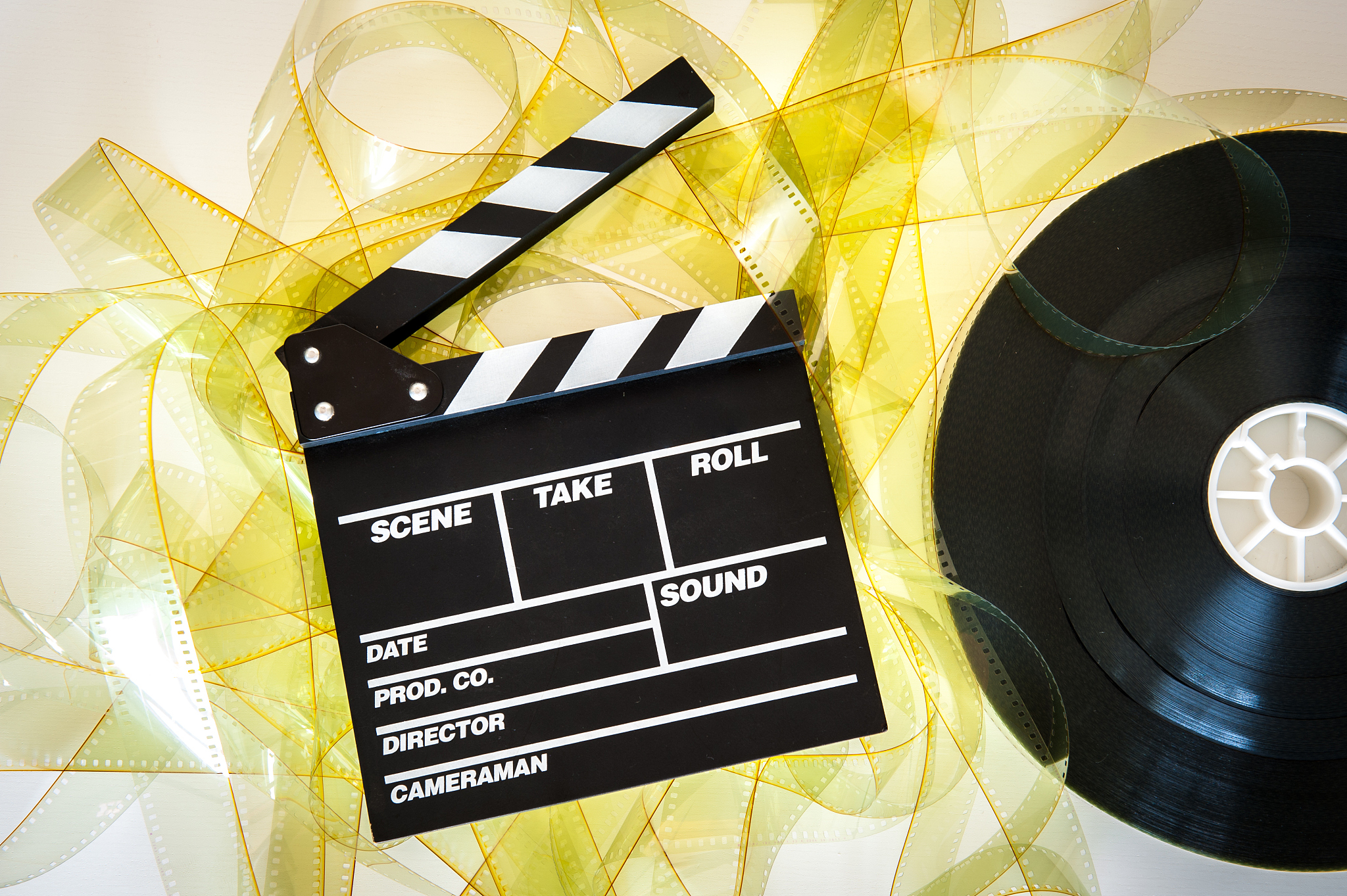 clapper board with 35mm film yellow frames and movie reel