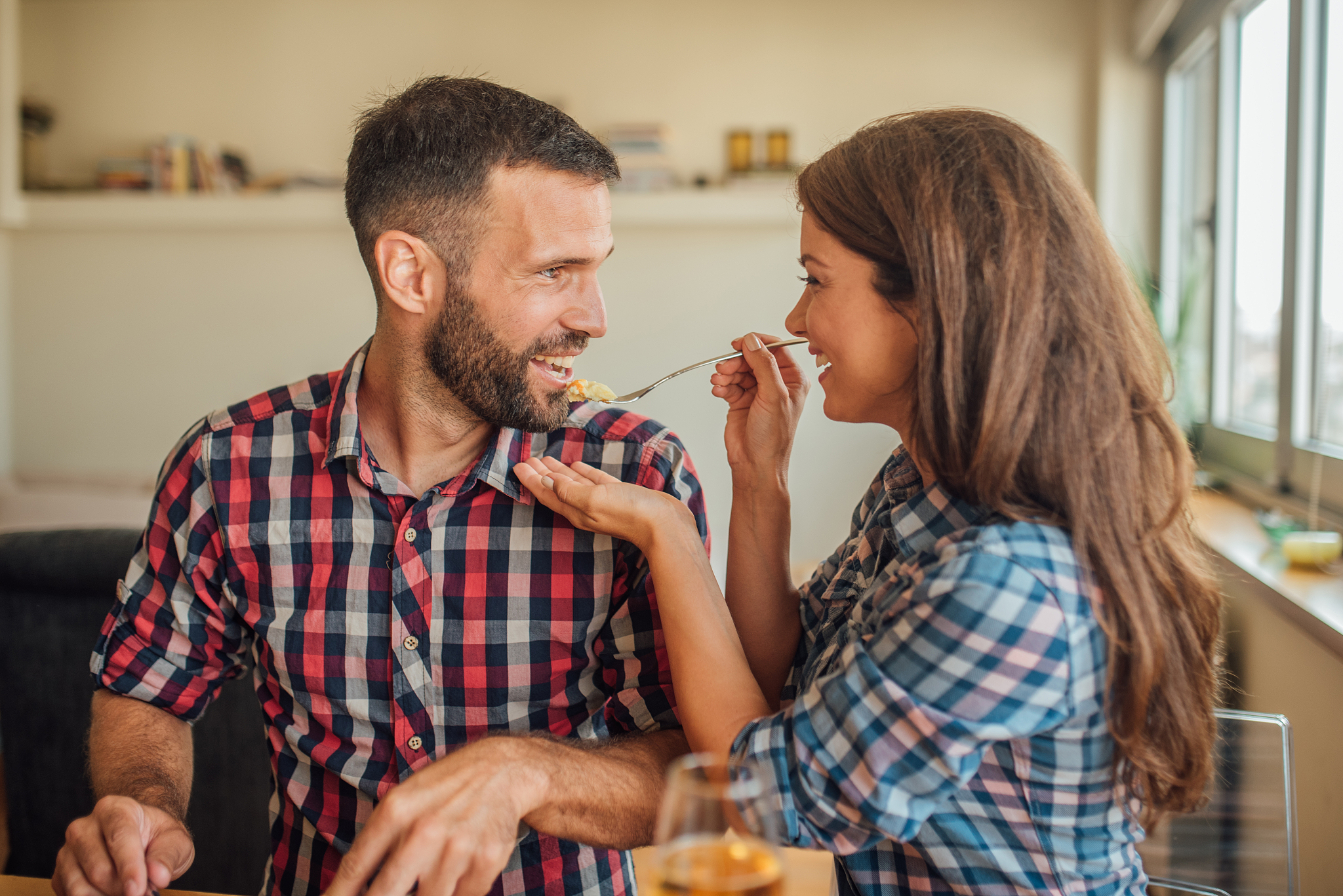 beautiful young woman offering the man a bite from her plate