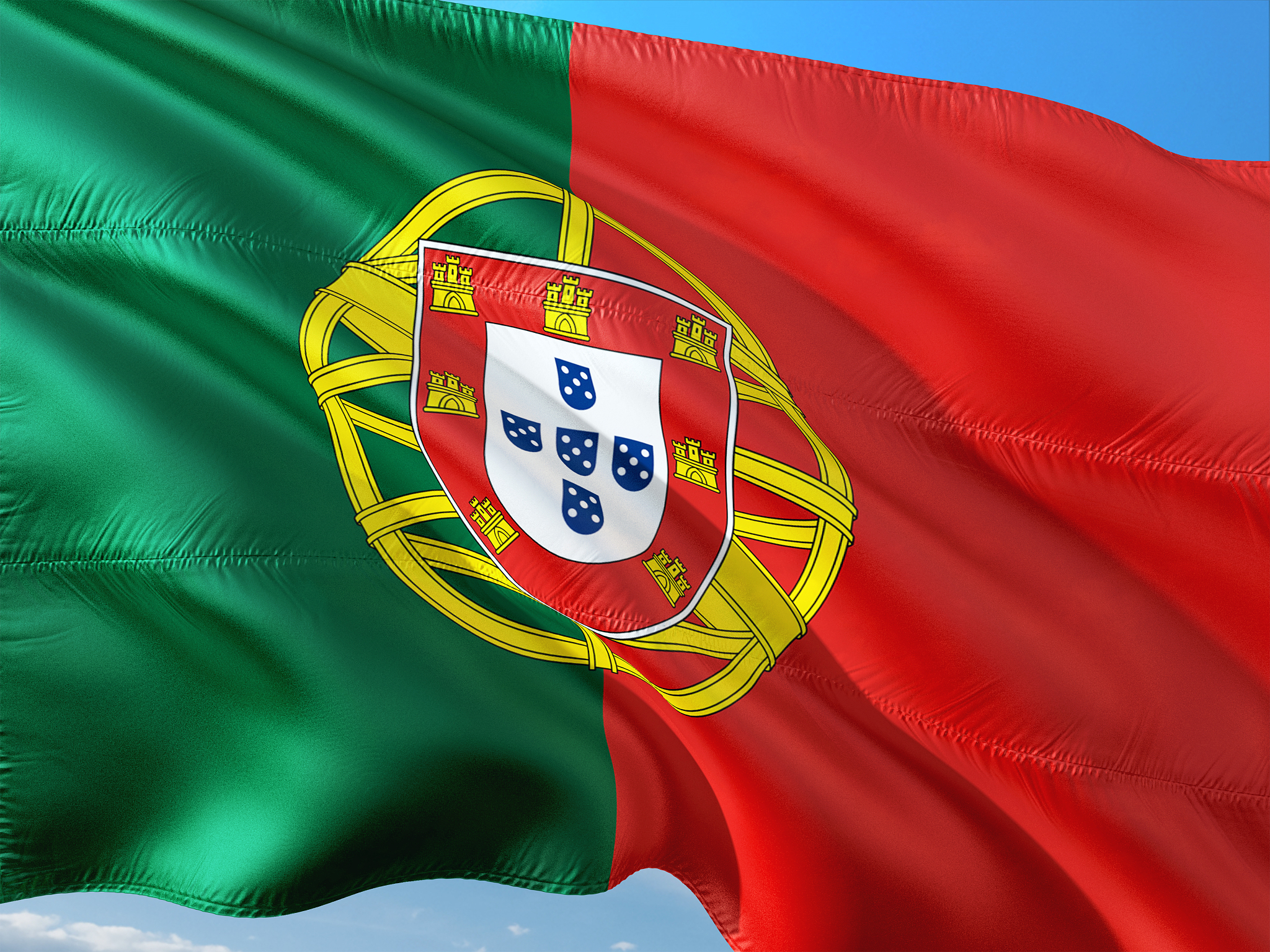 flag of portugal waving in the wind against deep blue sky. high 