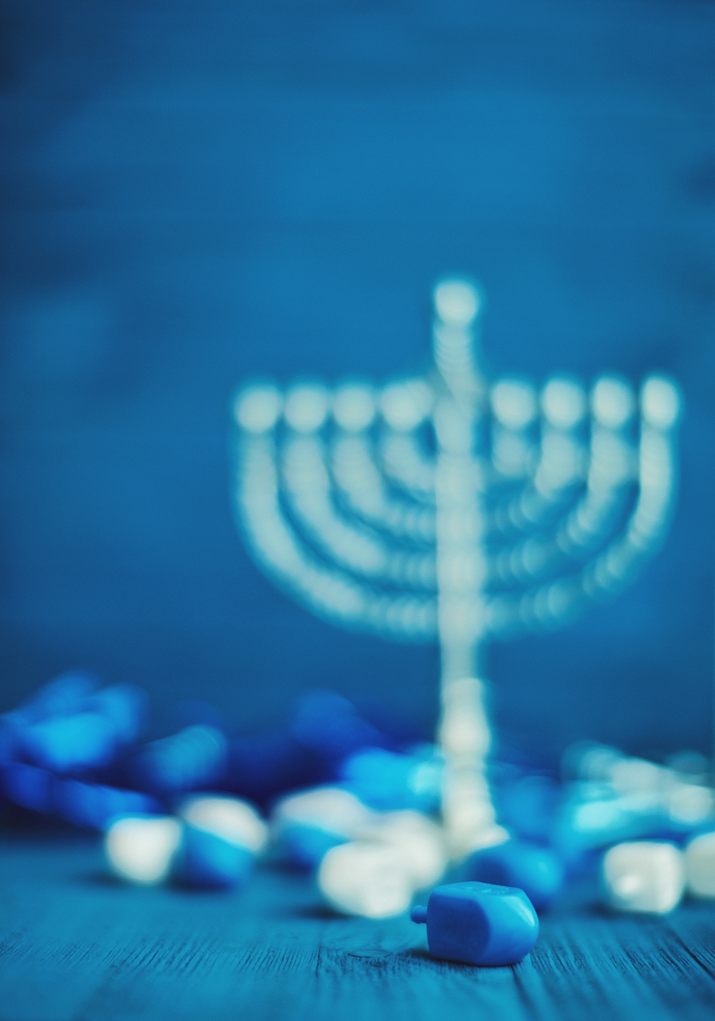 defocused hanukkah background with menorah and dreidel