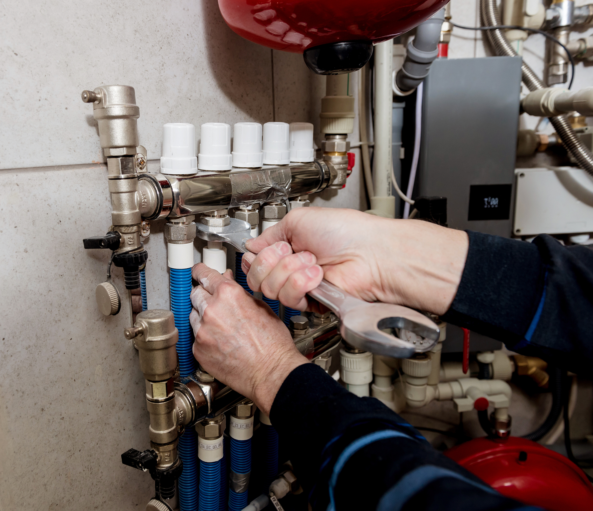 heating engineer installing modern heating system in boiler room