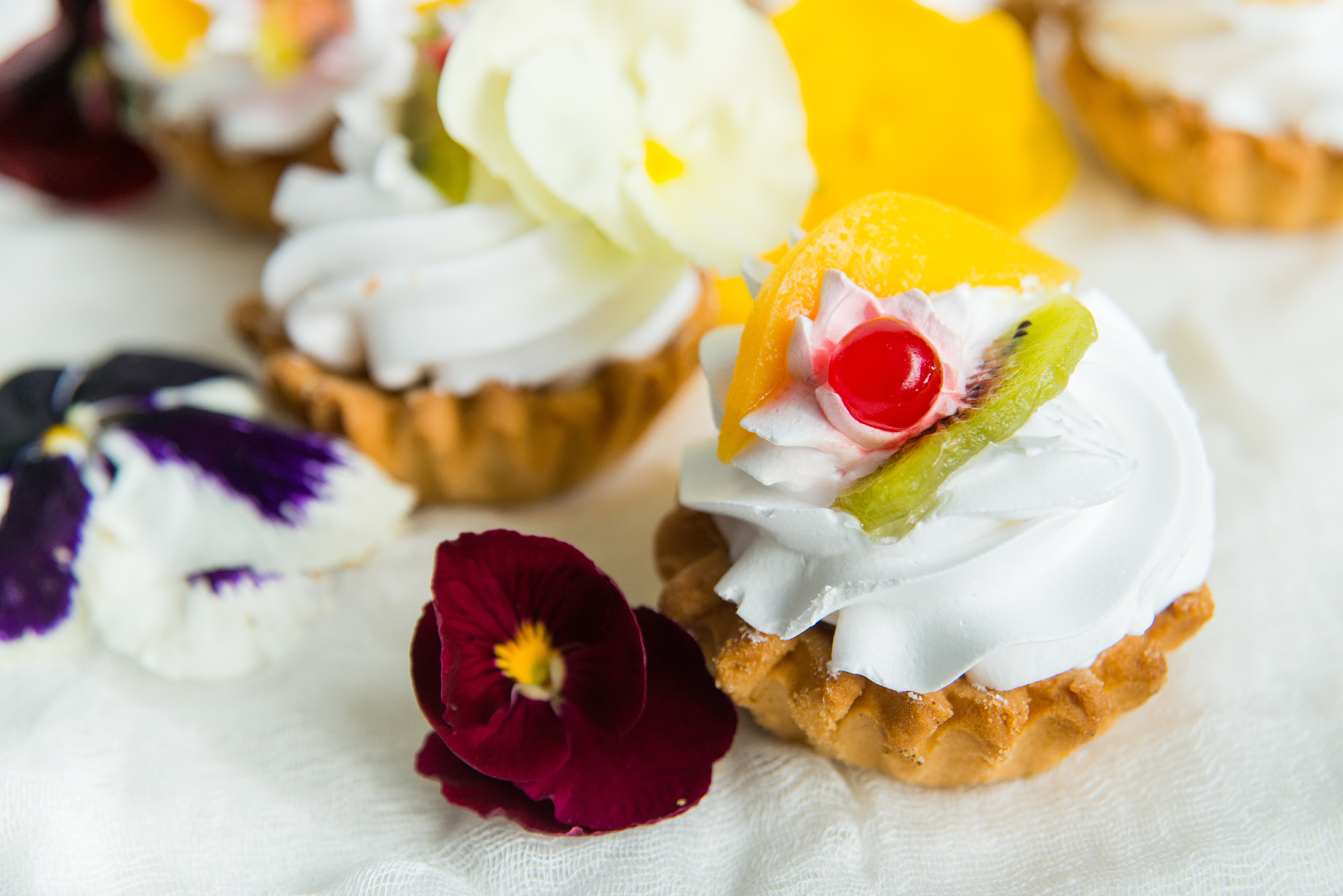 cake with fresh fruit and edible flowers pansy flowers on light 