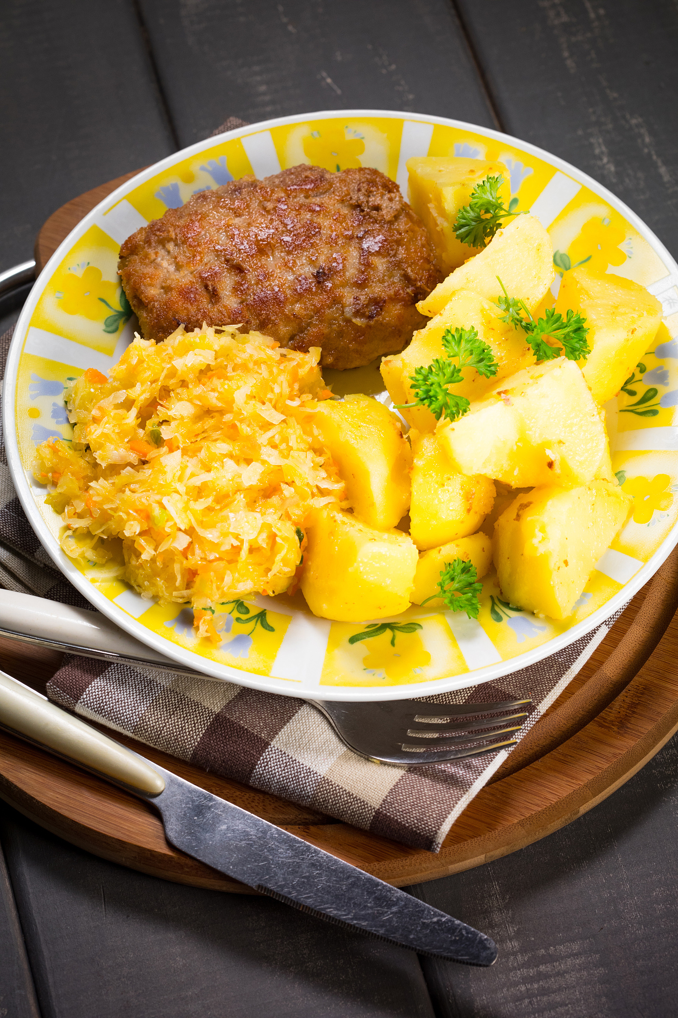minced pork cutlet served with potatoes and sauerkraut salad.