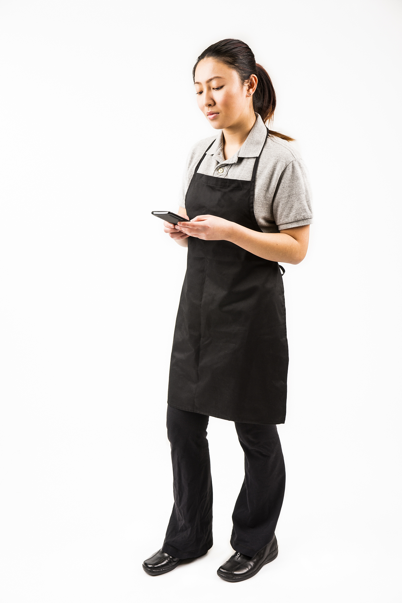 asian woman in a retail store uniform with her smartphone