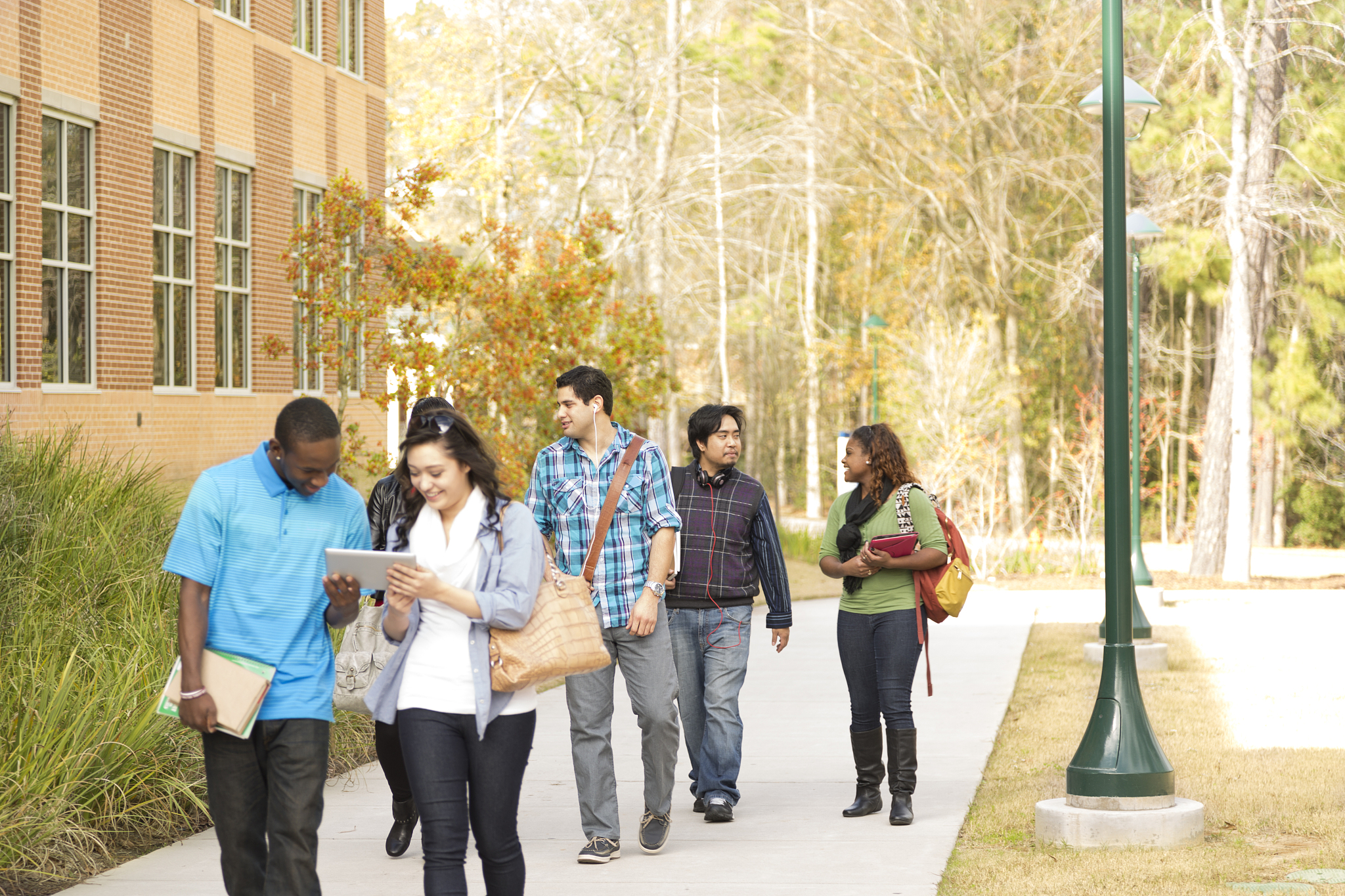 education: multi-ethnic group of college students walk to class.
