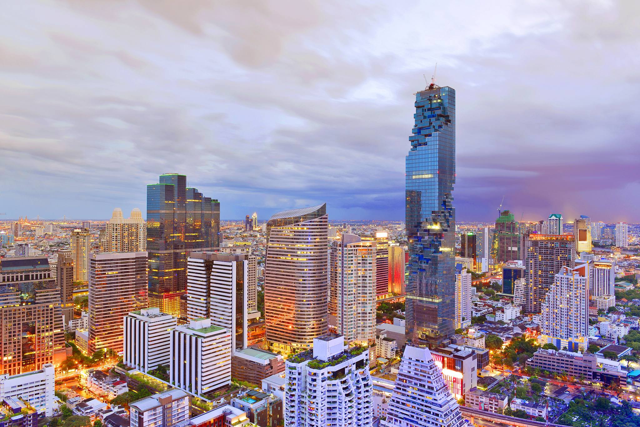skyscrapers in city against cloudy sky
