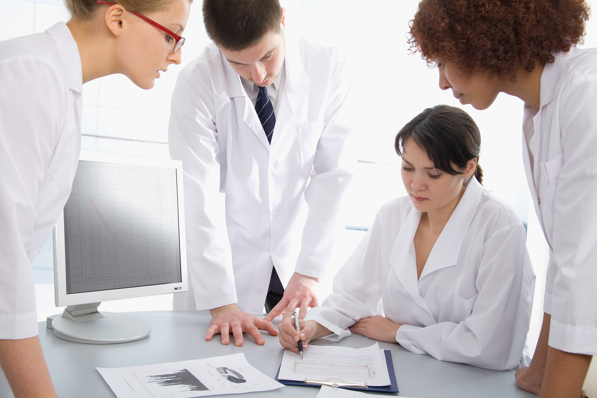 group of young doctors looking over chart
