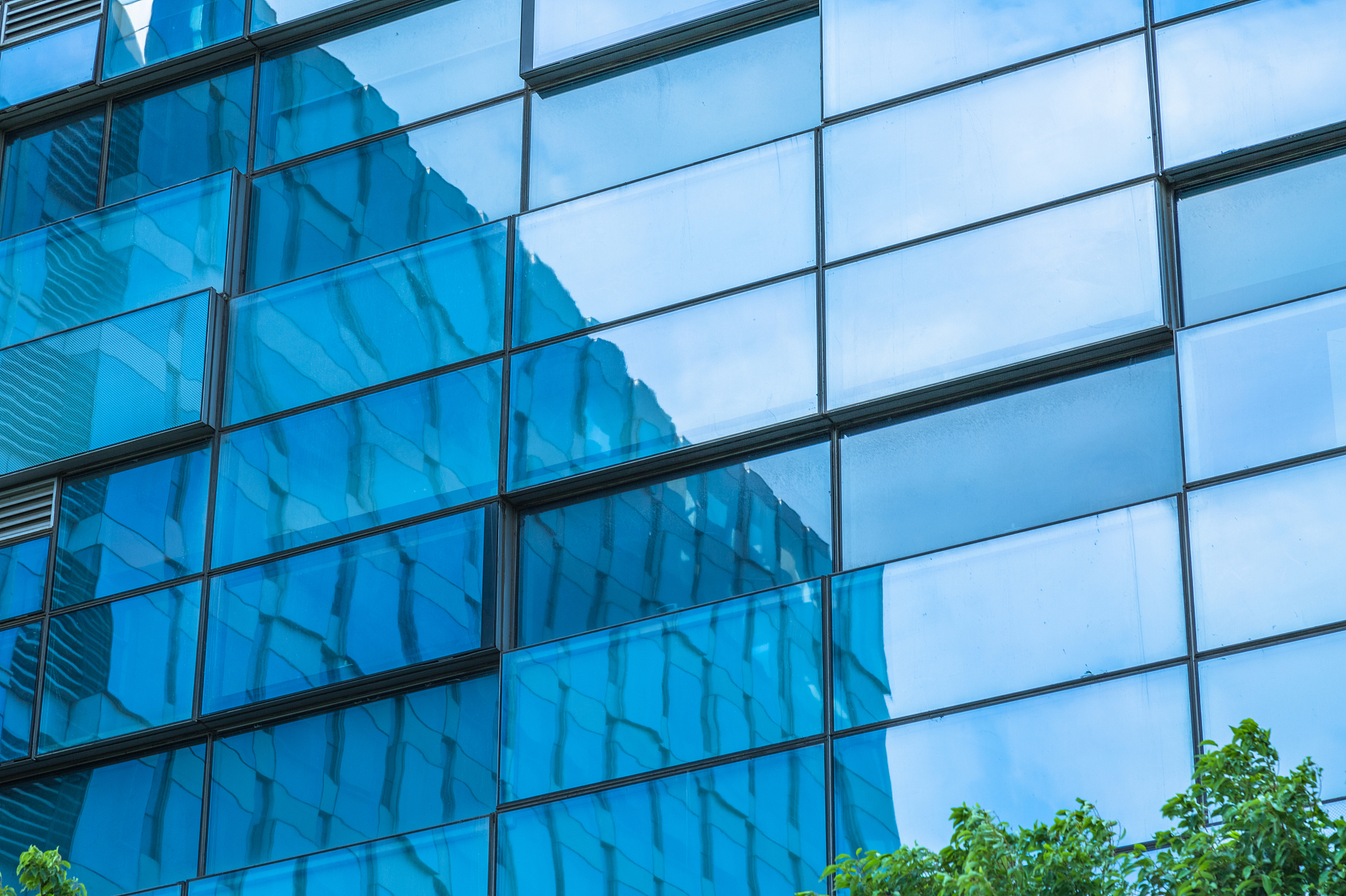 clouds reflected in windows of modern office building