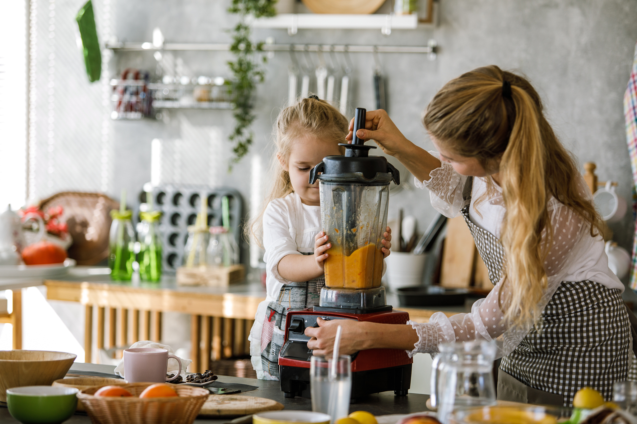woman and her daughter using a blender together for a dessert th