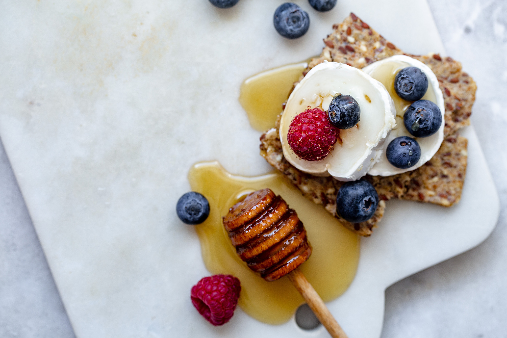 snack with crispbread, goat cheese and fresh fruits on white mar
