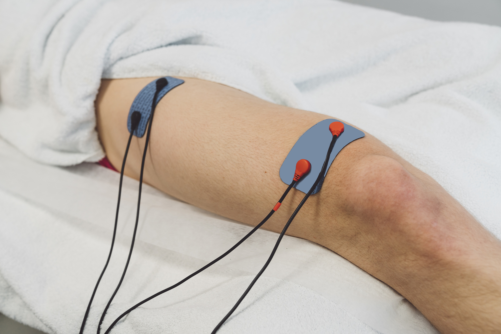 human leg with physical therapy machine on it, heating the muscl