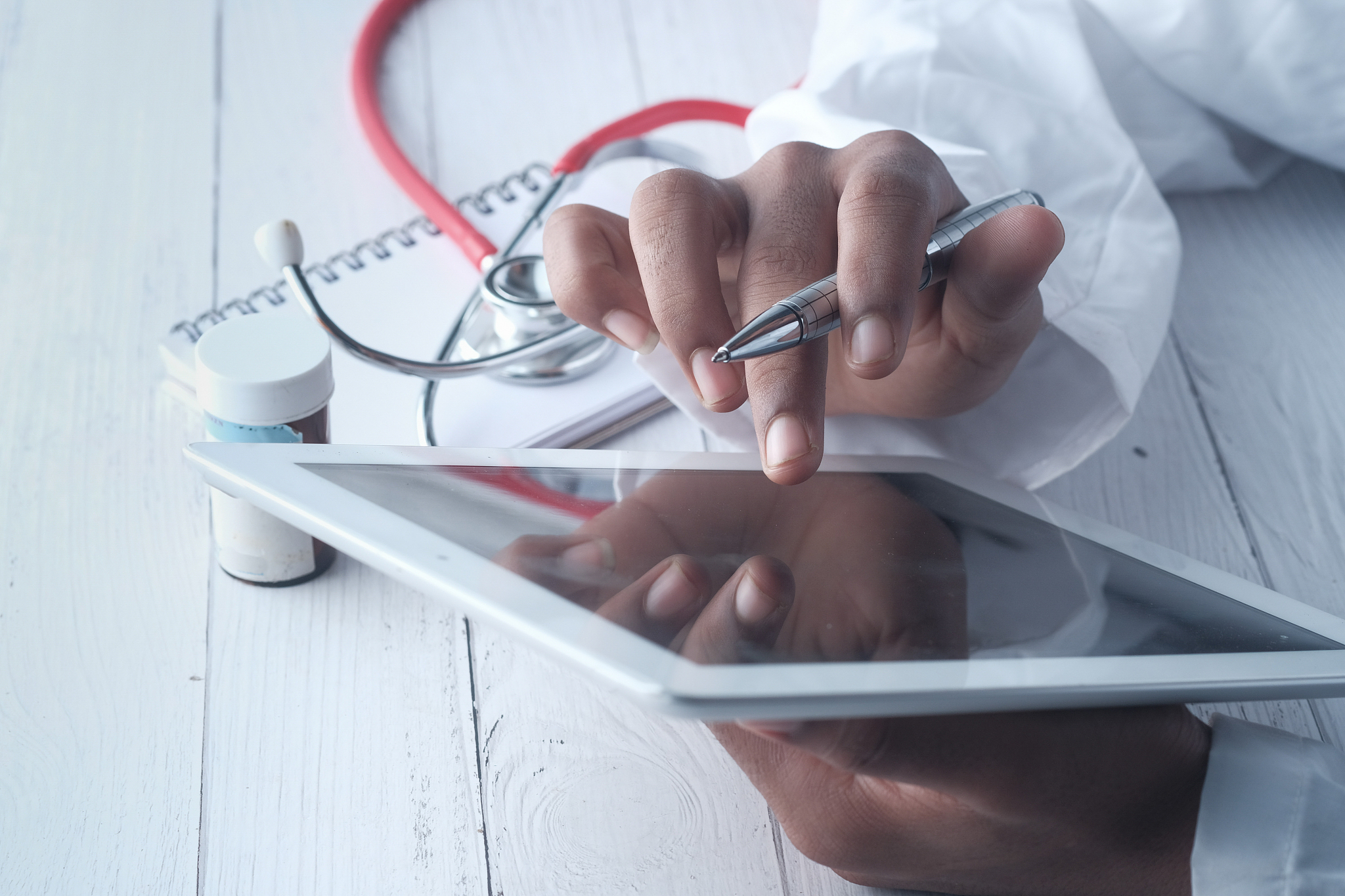 doctor hand holding digital tablet on table