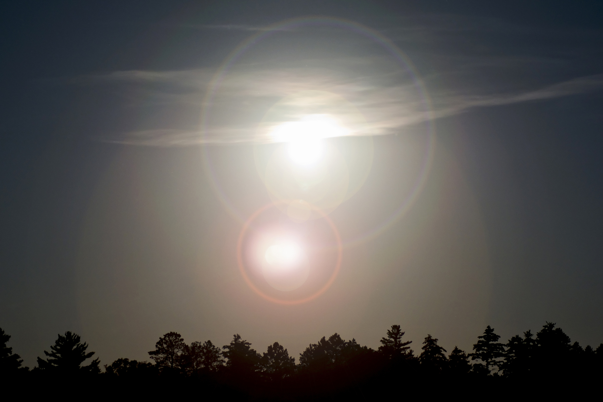 full moon above tree line with lens flare