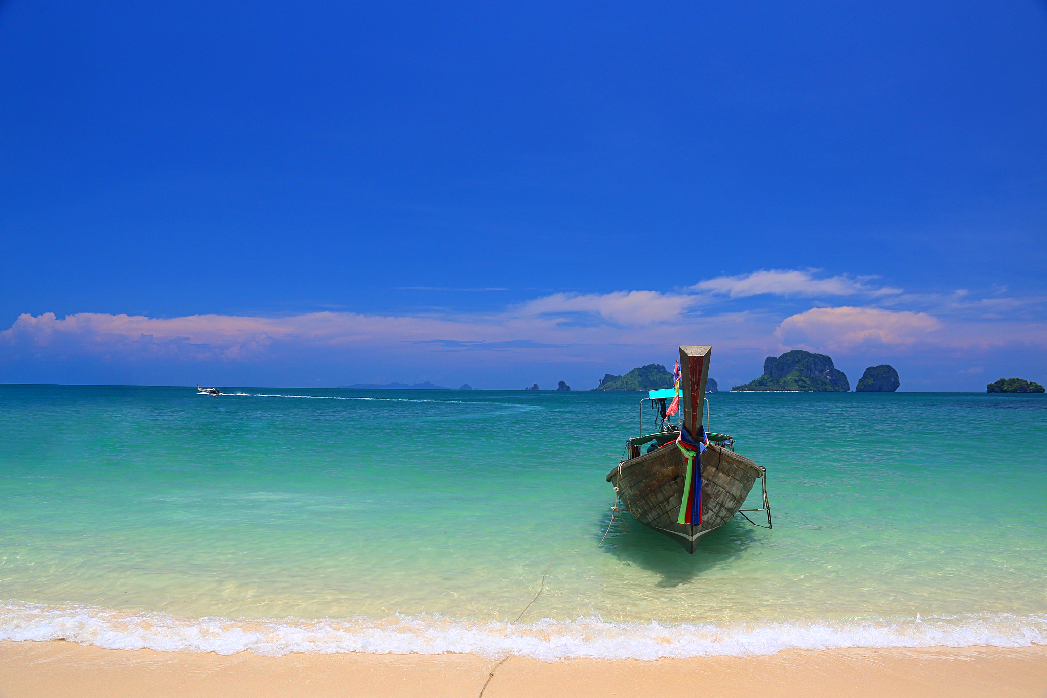 one boat is parked on the coast for tourists.