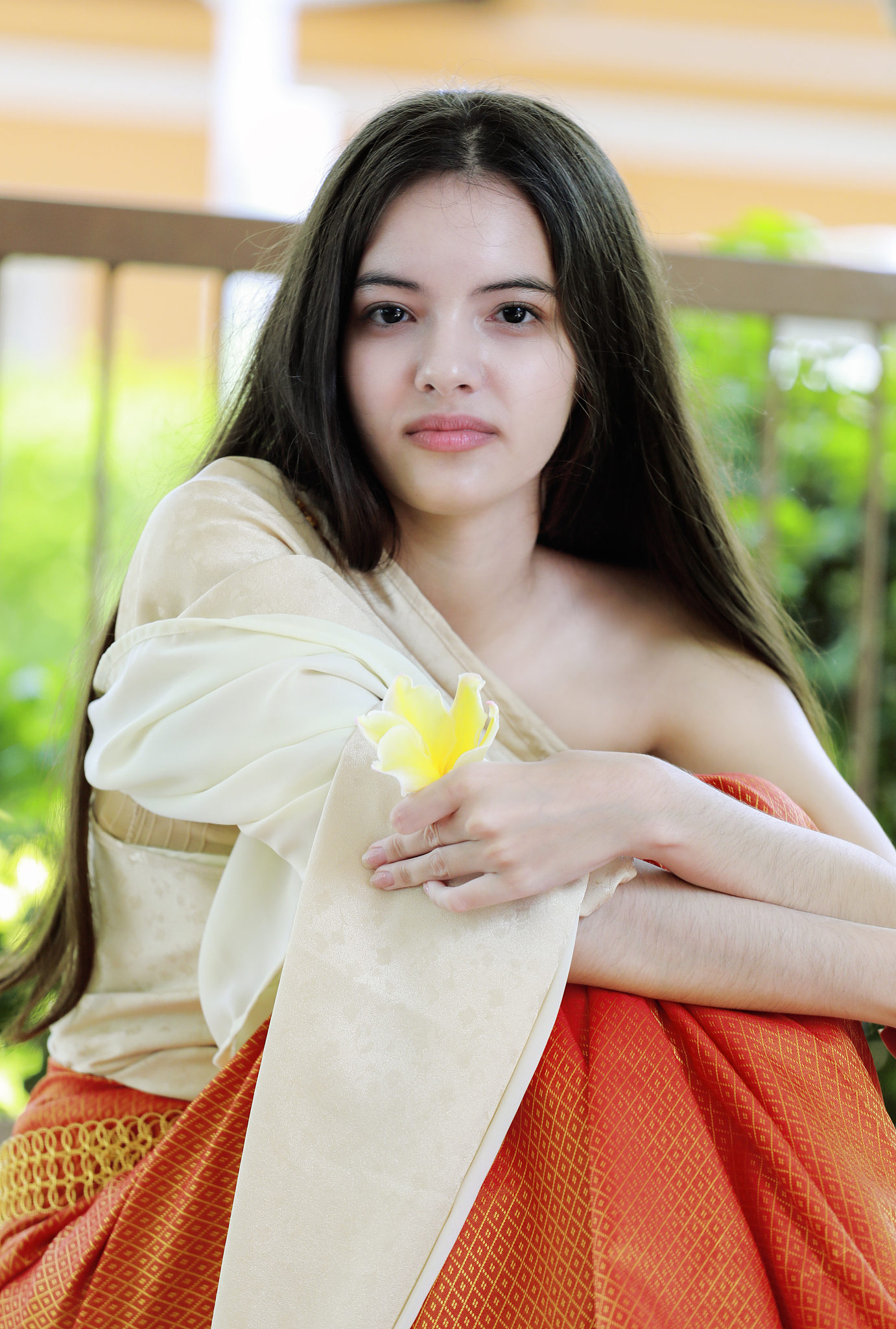 teen girl wear thai traditional dress sitting and looking for ne