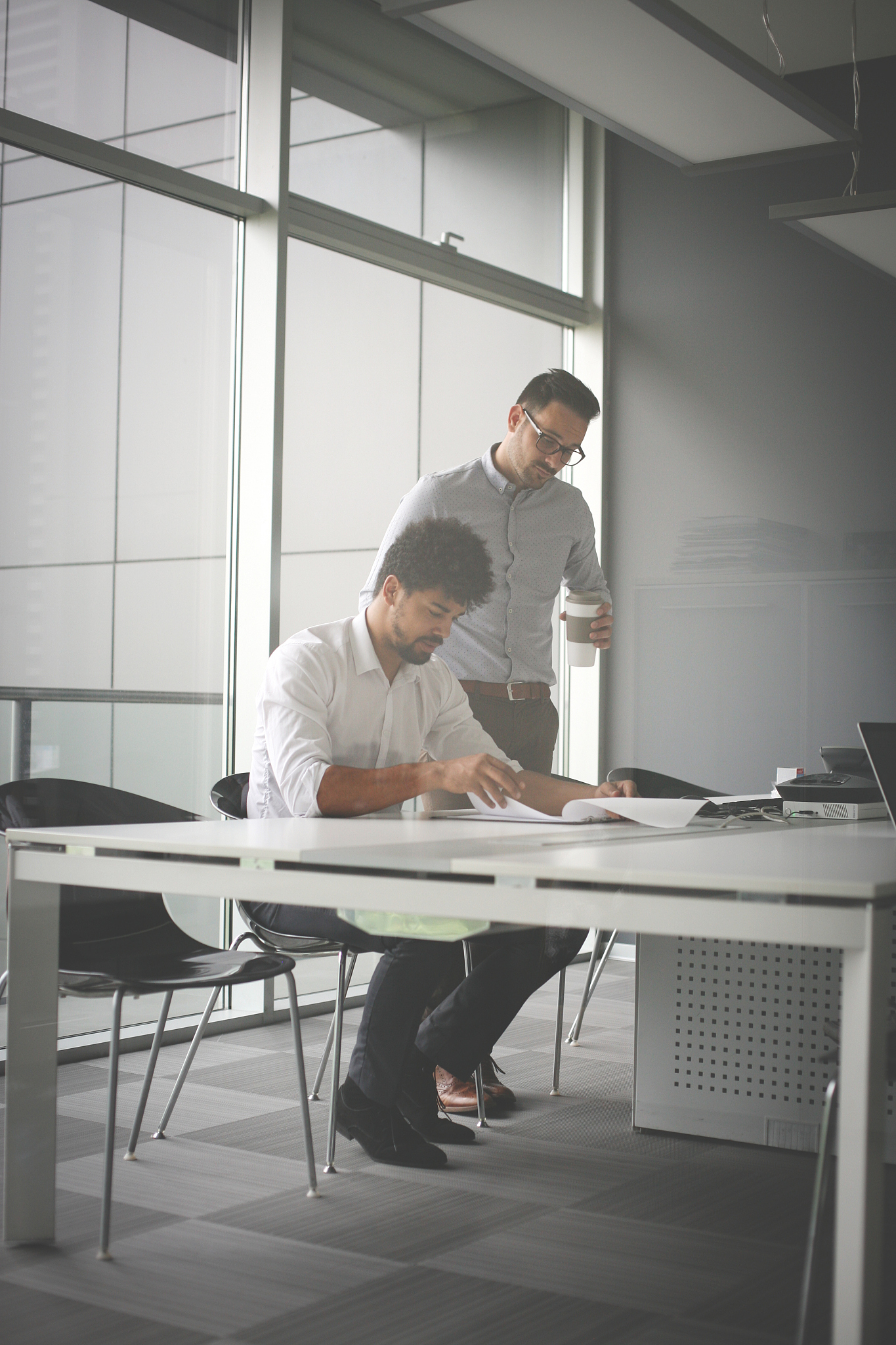 two business men working together in office. reading document.