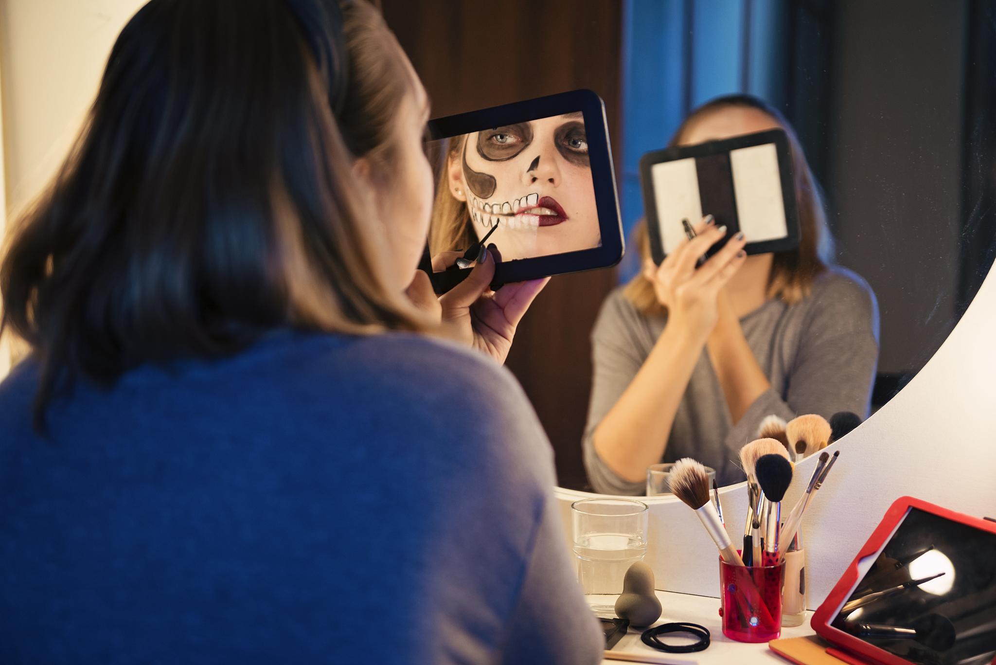 young woman following a halloween makeup tutorial on social medi