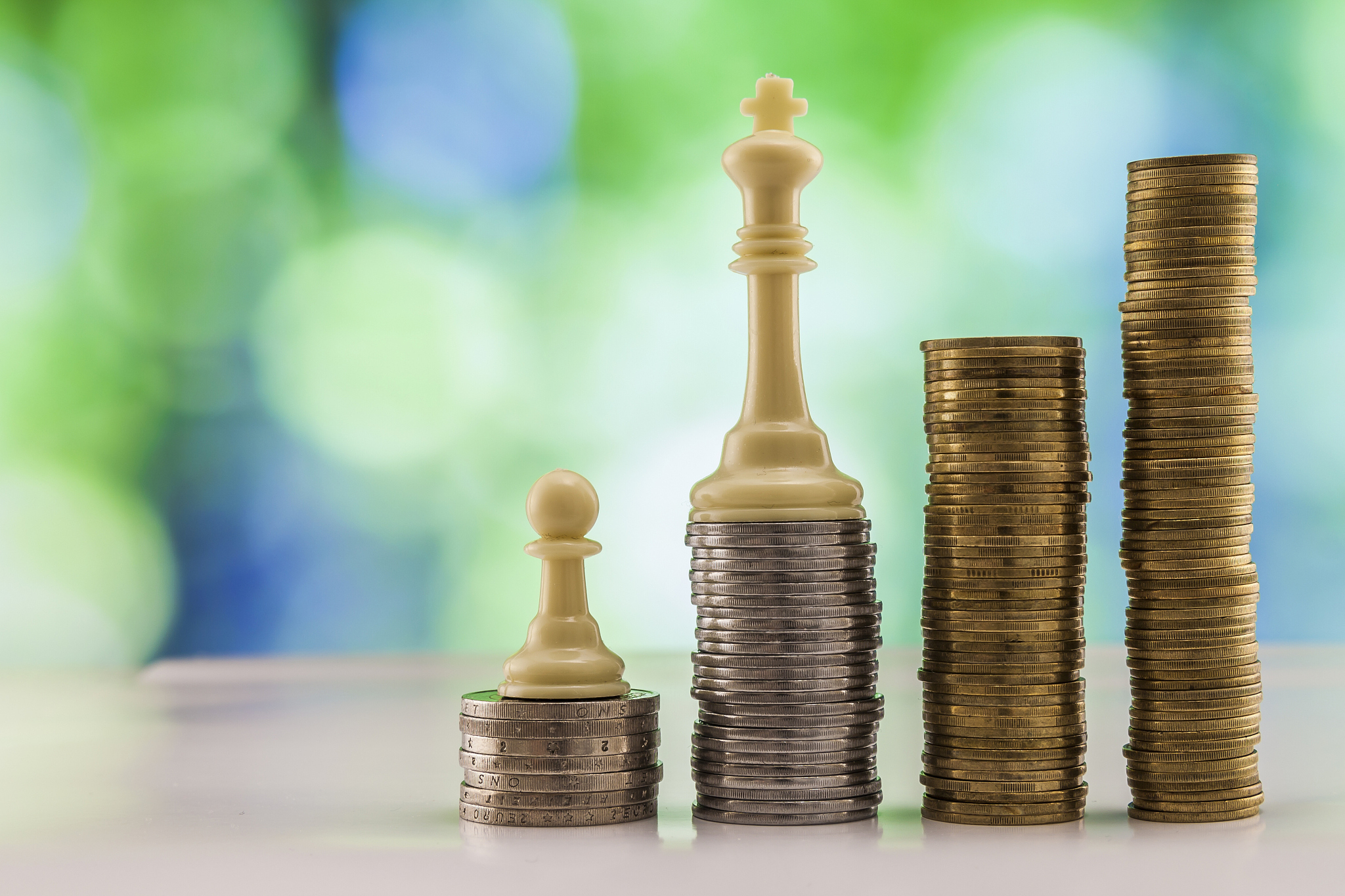 growing coins stacks with green and blue sparkling bokeh backgro