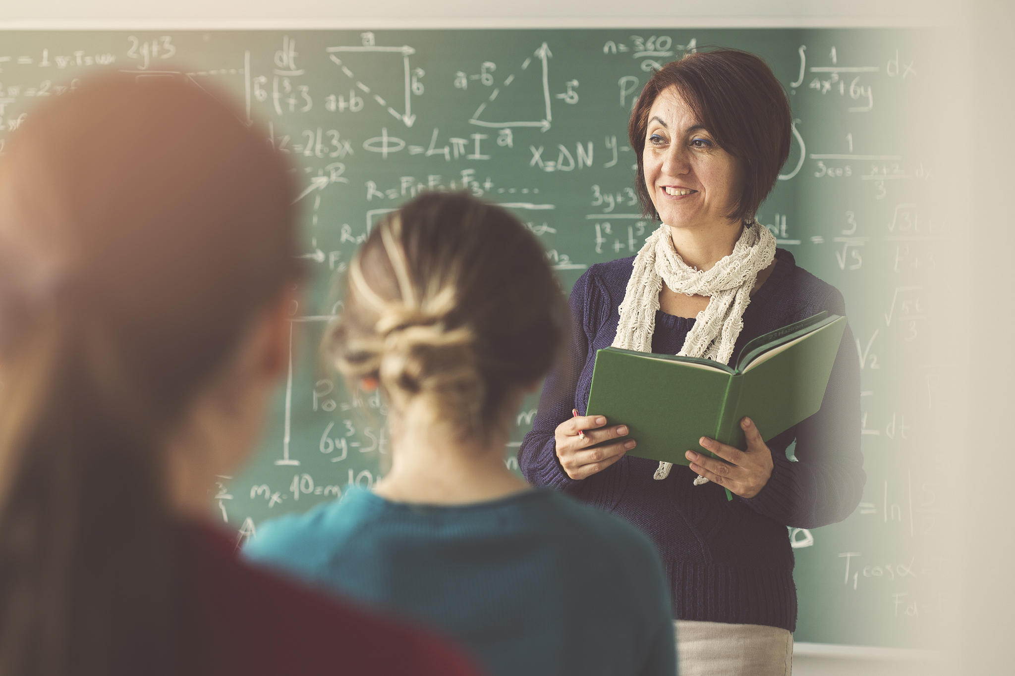 teacher giving lesson to students in  classroom