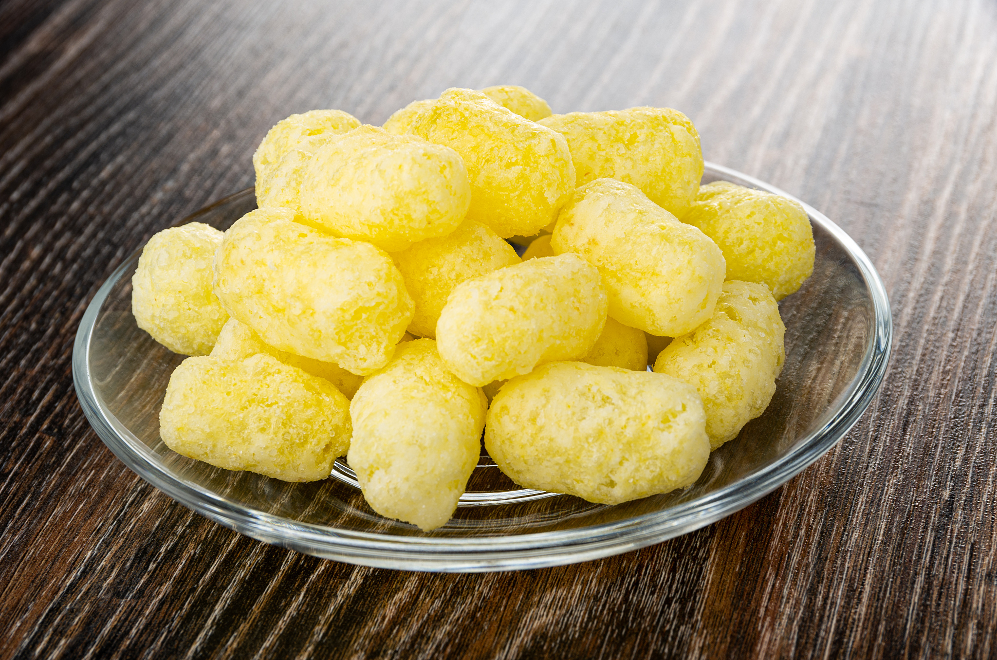 sweet corn sticks in transparent saucer on wooden table