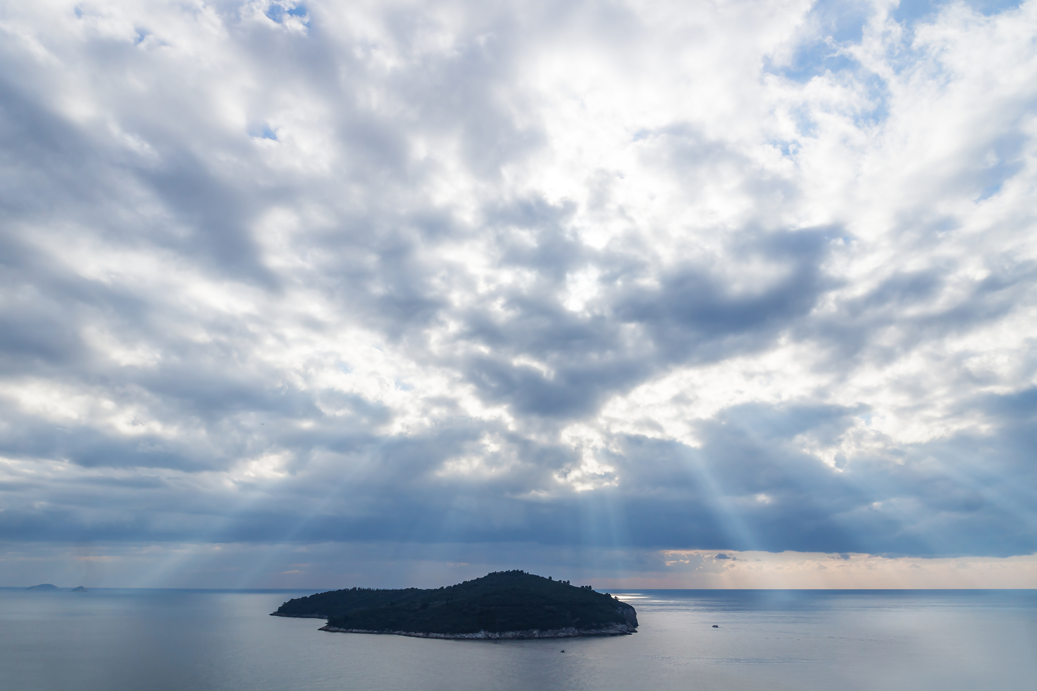 sunrays over lokrum island in front of dubrovnik, croatia