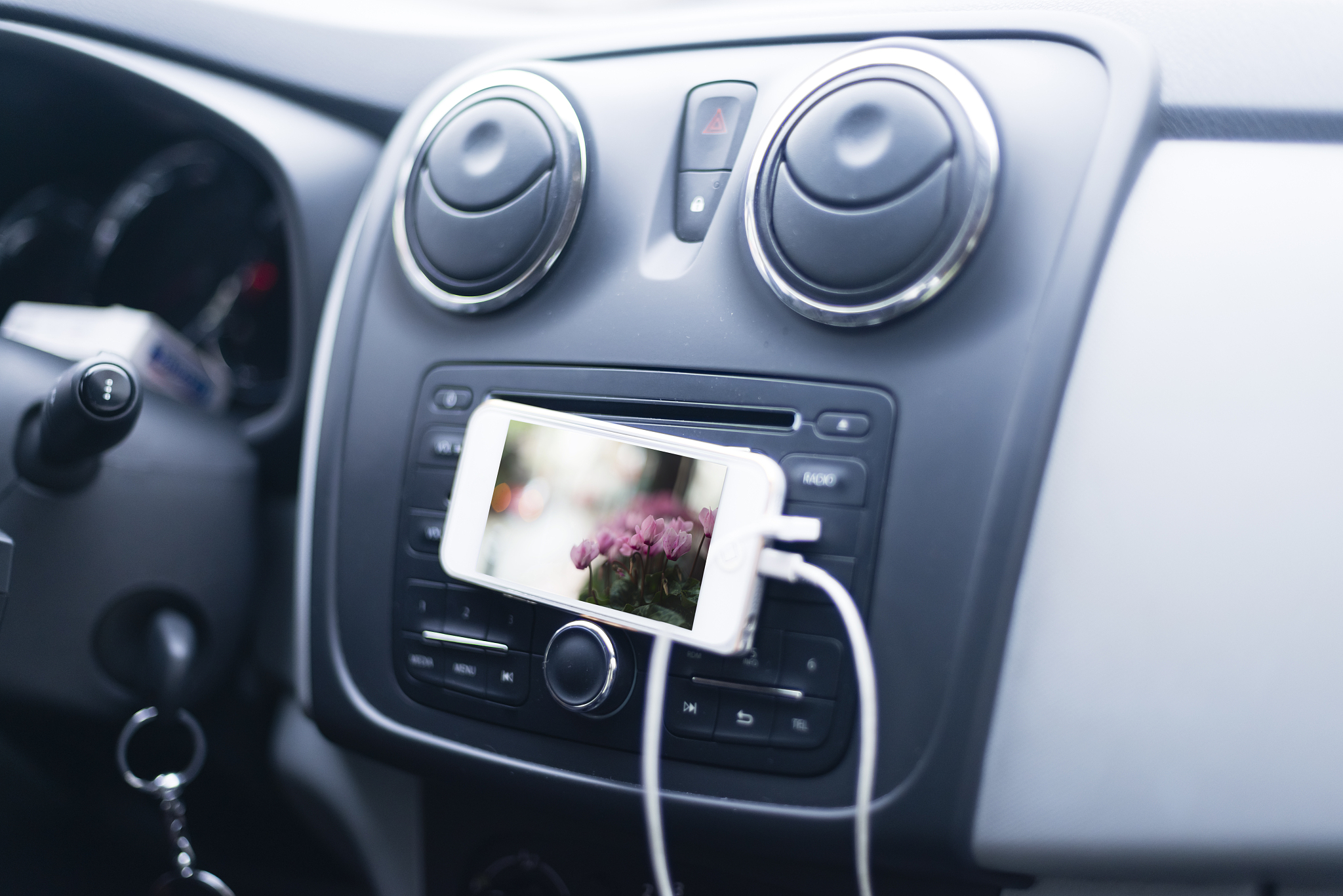 plugged in iphone playing a movie on the dashboard of a car