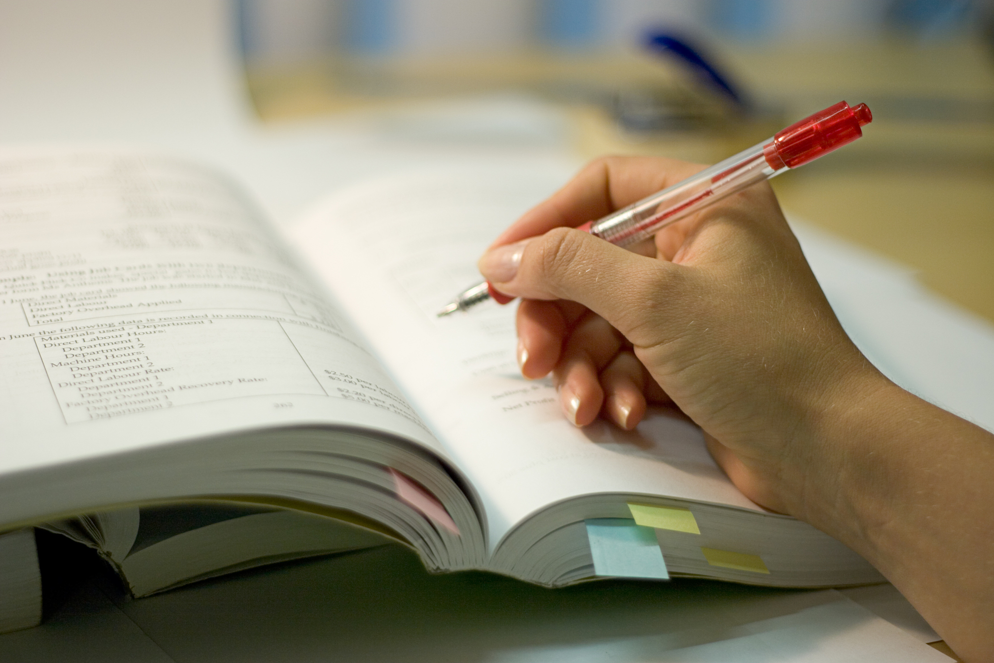 open books and a hand with pen
